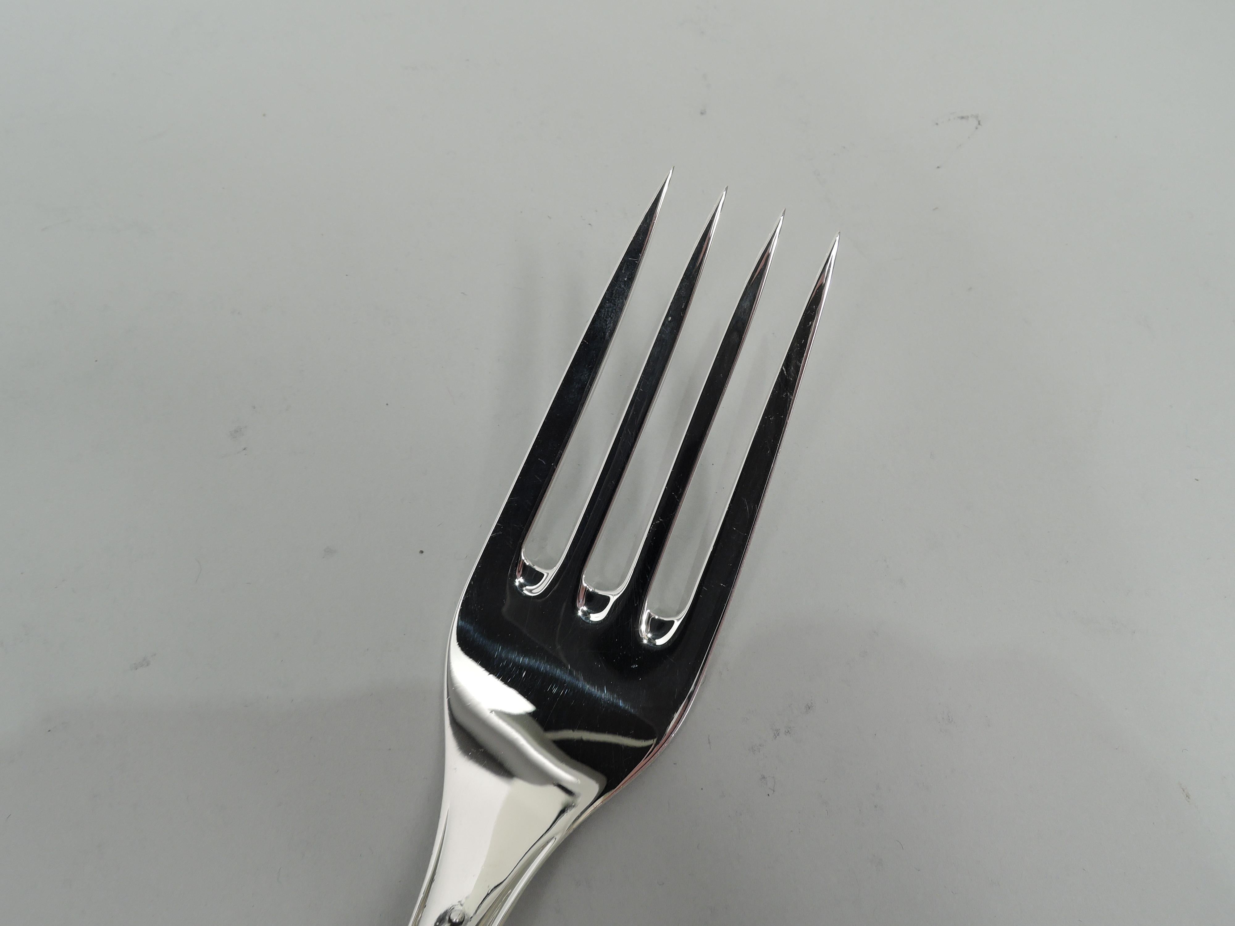 Anacapri sterling silver cold meat fork. Made by Buccellati in Italy. Wide and plain stem with upturned terminal. Low relief scrolling leaves and pendant flowers on shoulder. Shank has four straight tines. Marked “Buccellati Sterling Italy”. Very