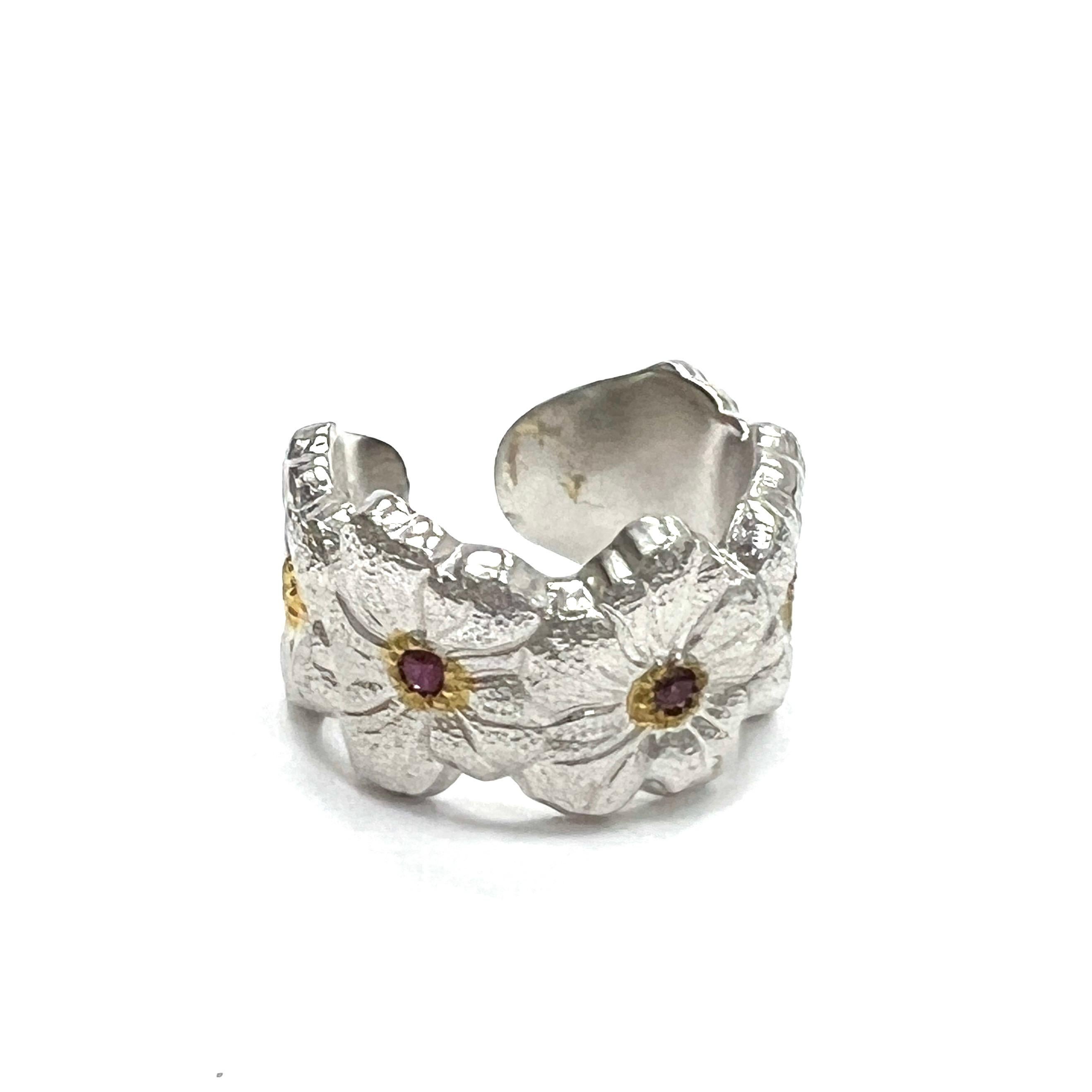 Buccellati Blossoms Ruby Sterling Silver Ring, Italian

Blossoms flowers made of sterling silver with round-cut bezel-set rubies of approximately 0.10 carat; marked Buccellati, Italy, 925, Sterling

Size: 6.5 US; width 1.2 cm
Total weight: 11.6 grams