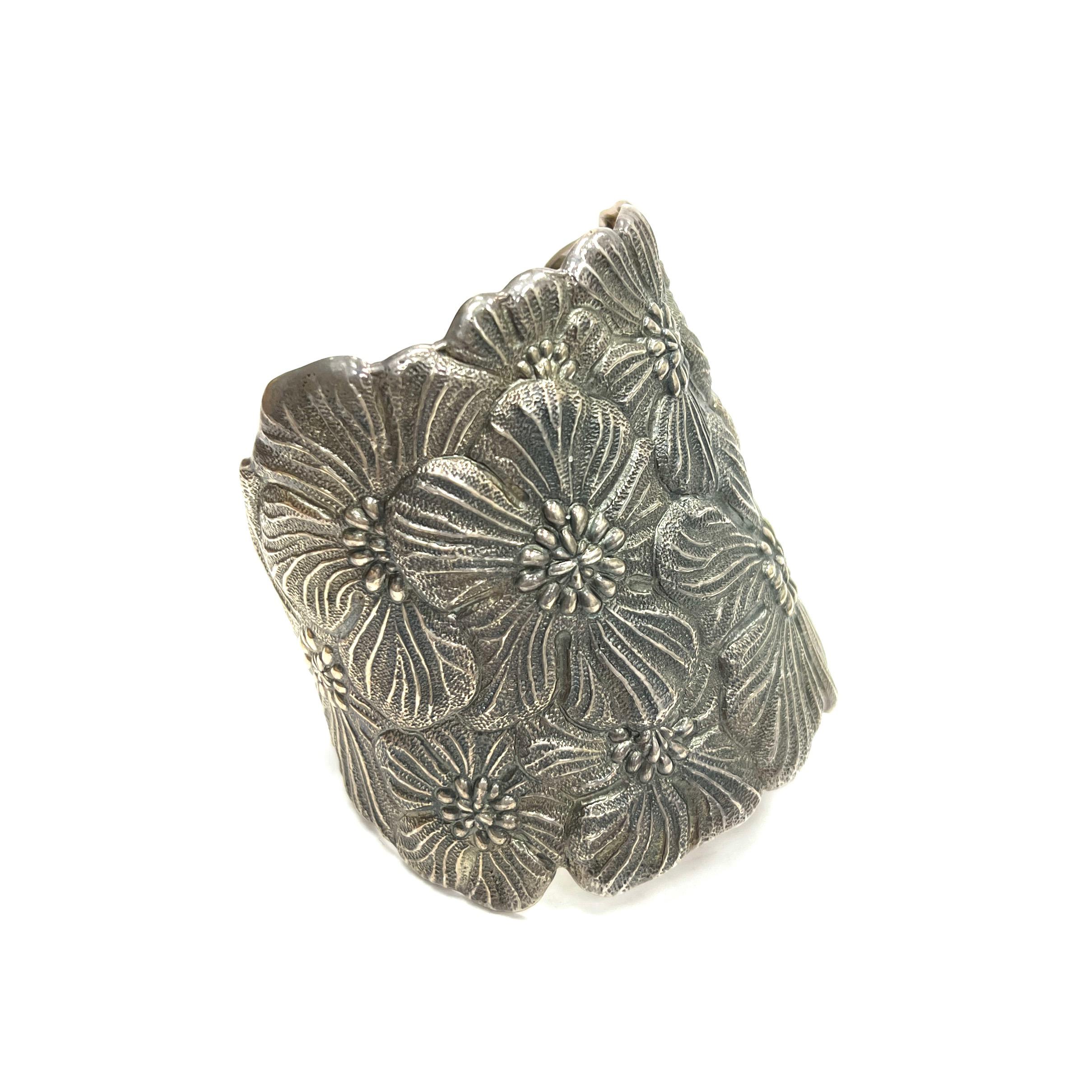 Bracciale in argento scuro e largo con fiori di Buccellati.
Fiori di fiori in argento scuro; marchiato Buccellati, Italia, 925, Sterling
Dimensioni: larghezza 2,63 pollici; circonferenza interna 6,5 pollici
Peso totale: 99,9 grammi