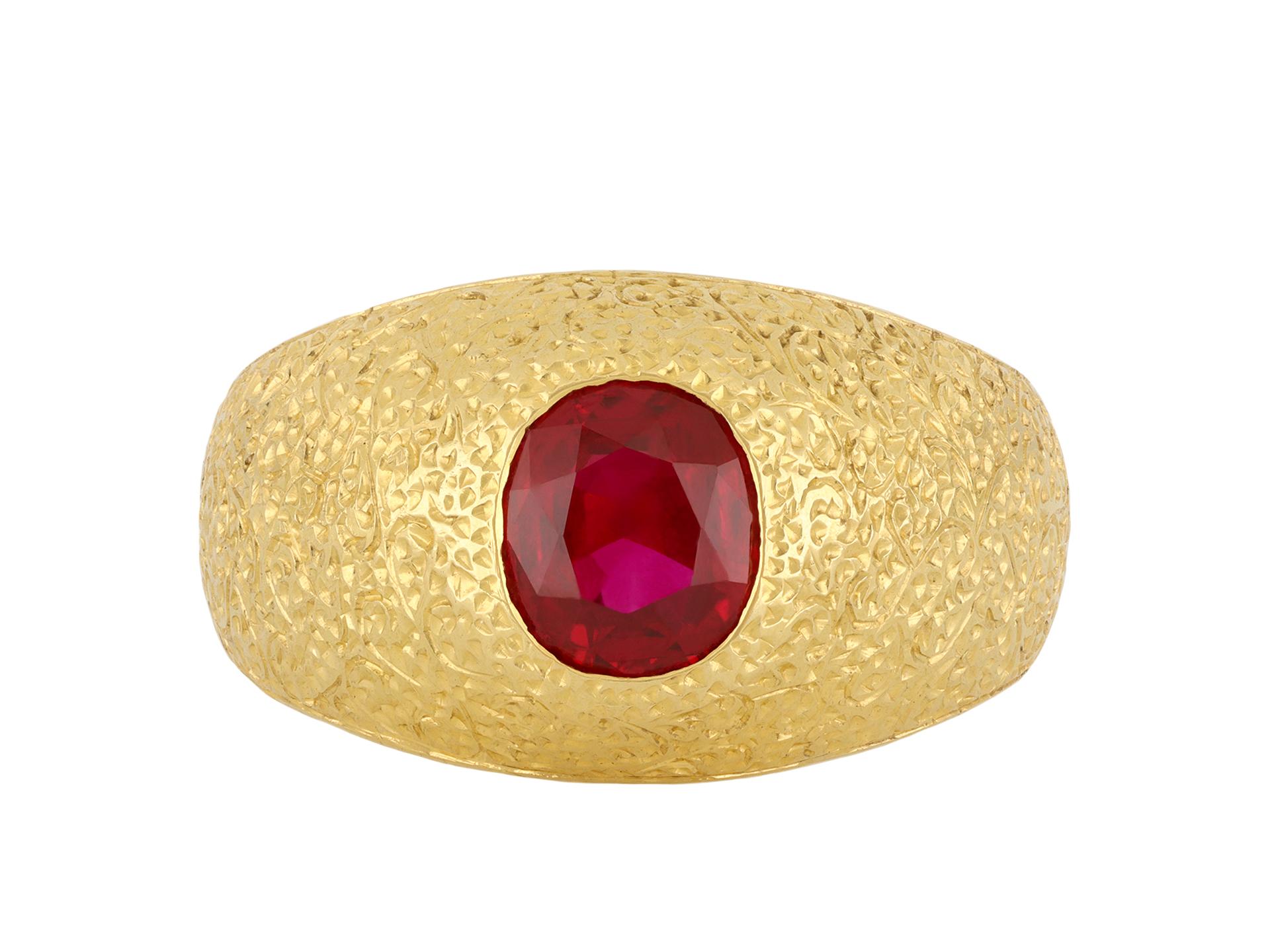 Buccellati Burmese ruby ring. Set with an oval mixed cut natural unenhanced Burmese ruby in an open back rubover setting with an approximate weight of 1.20 carats, to an impressive solitaire design featuring engraved detail throughout in a textured