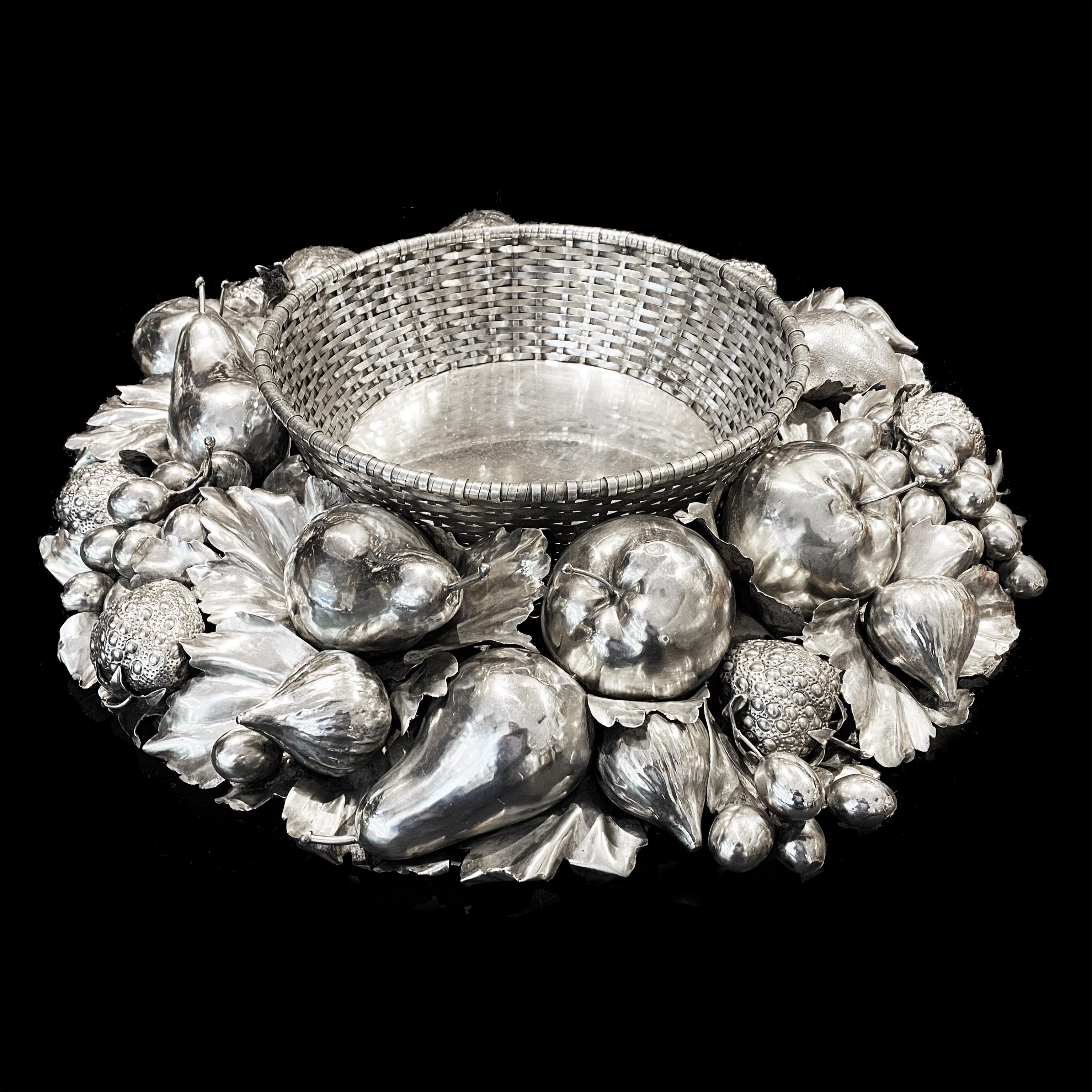 Large sterling silver centerpiece created and signed by famous Italian silversmith Gianmaria Buccellati.
The centerpiece is circular and composed of a central wicked basket style surrounded by chiseled fruits such as grapes, strawberry, pear,