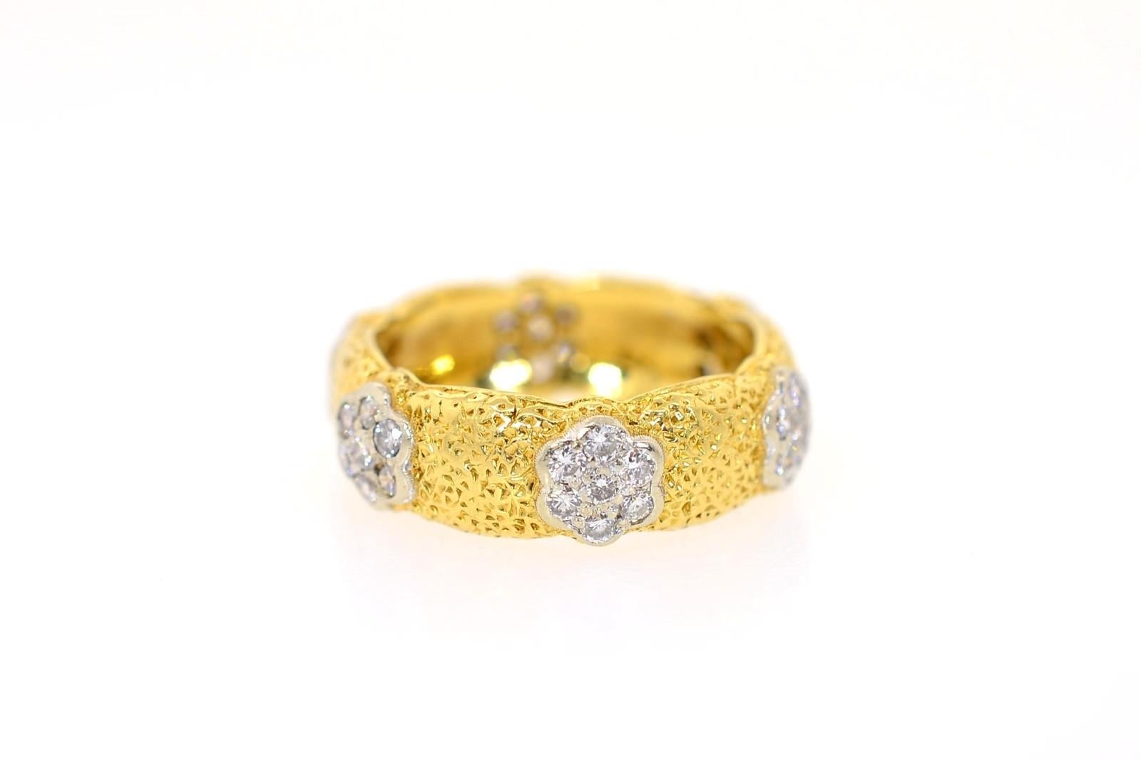 The craftsman of Buccellati created this beautiful band of 18KT yellow gold.  Six clusters of Round Diamonds totaling 0.80 carat, set in white gold highlight the ring and add sparkle.  The texture is iconic Buccellati hand engraving and the rim is