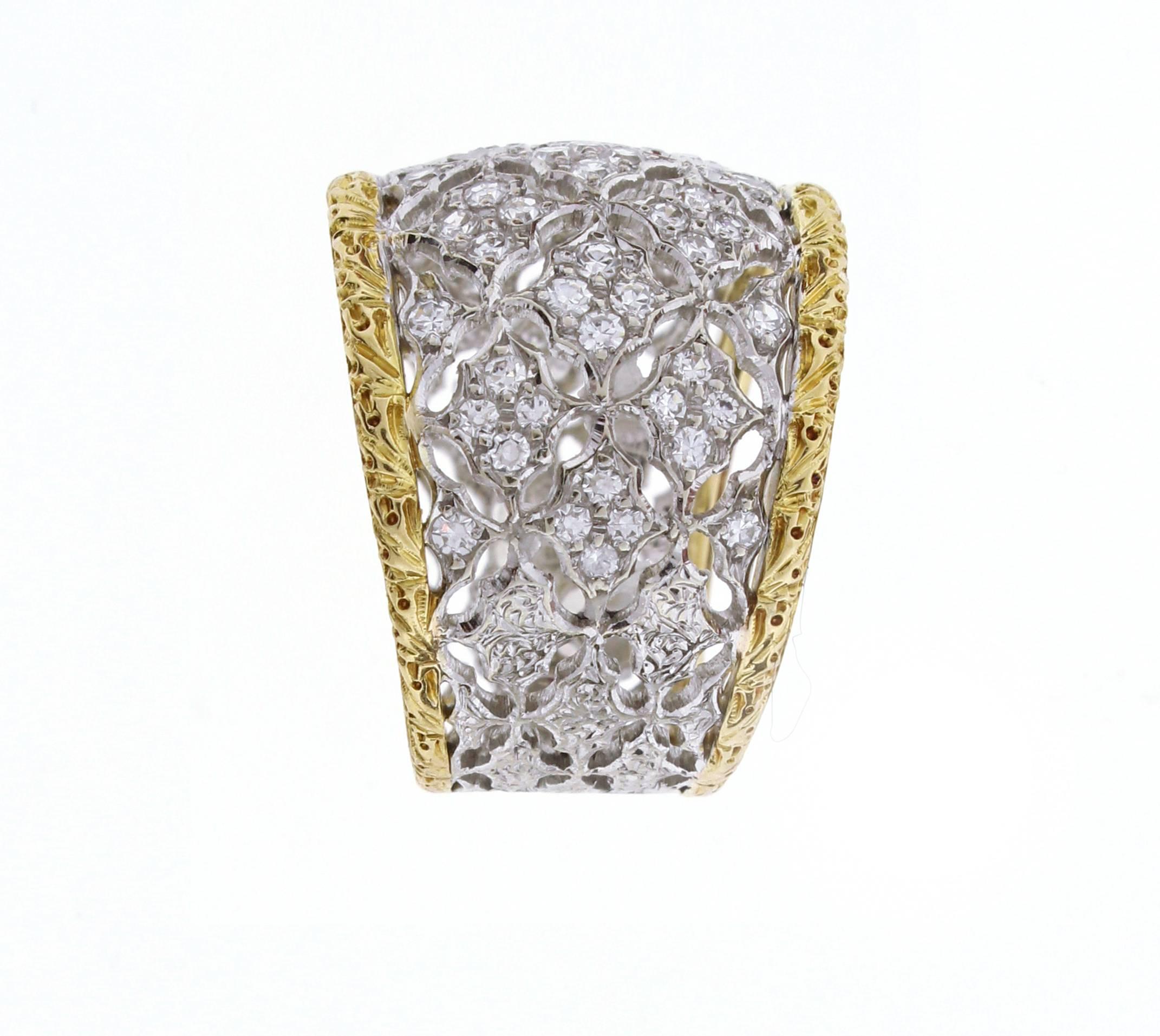  Federico Buccellati ring in 18 Karat yellow and white gold. 
This wide diamond ring features white gold filigree set with sixty two brilliant cut diamonds weighing .60 carats edged with yellow gold filigree. The ring tapers from 16mm to 10mm 8.4