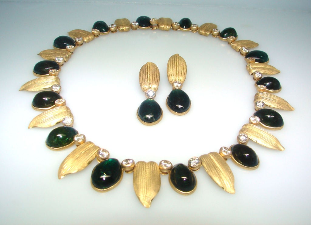 Exquisite set consisting of a necklace and a pair of earrings created by Buccellati in the 1960's.
Made of yellow gold, features approximately 120 carats of cabochon green tourmaline and accented with approximately 15.48 carats of round brilliant