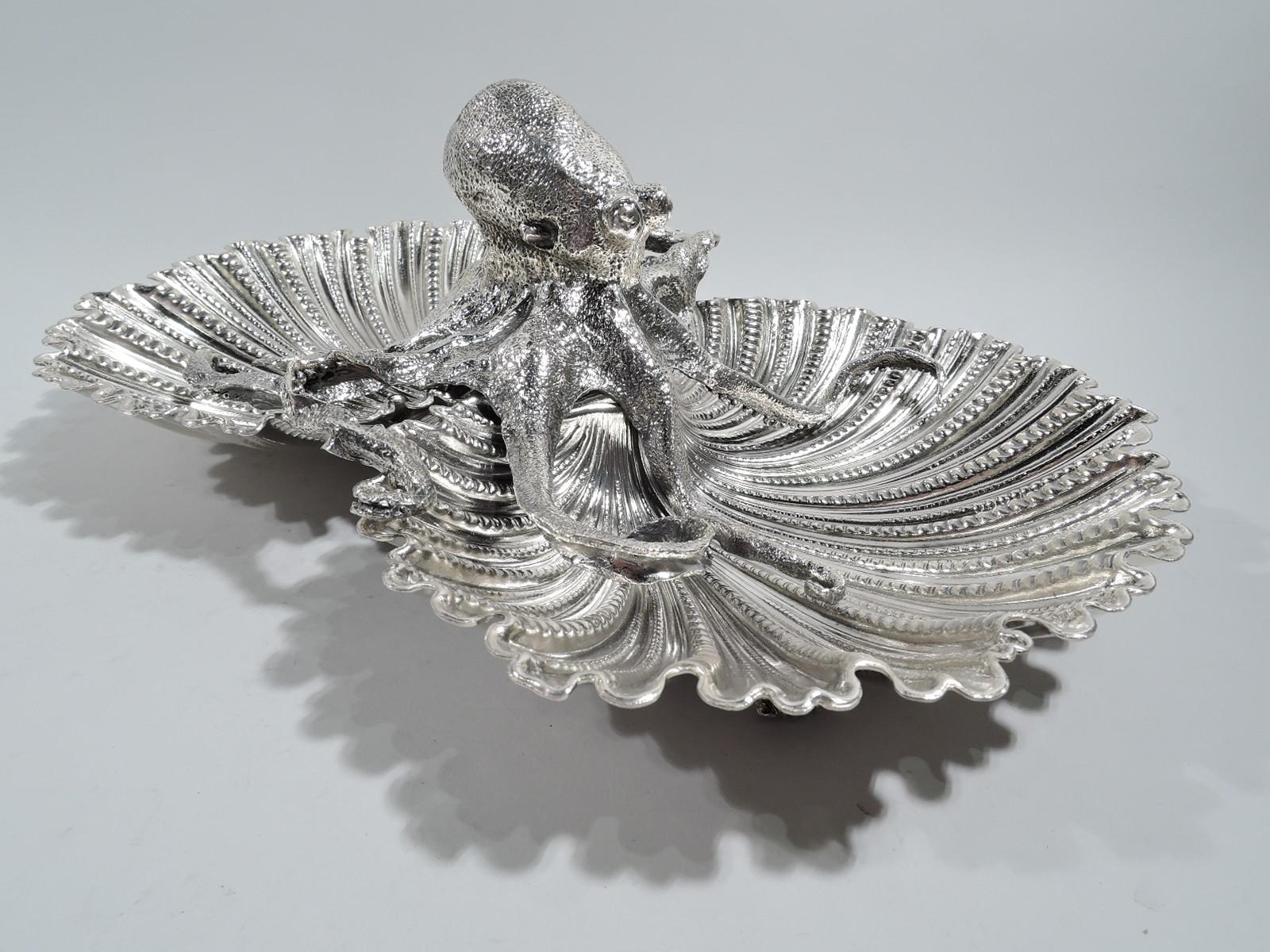 Dramatic sterling silver seafood serving bowl. Made by Buccellati in Italy. Two joined scallop-shells bowls on scallop-shell supports. A traditional form enlivened by the figure of an octopus squatting in the center, its curled and tangled legs