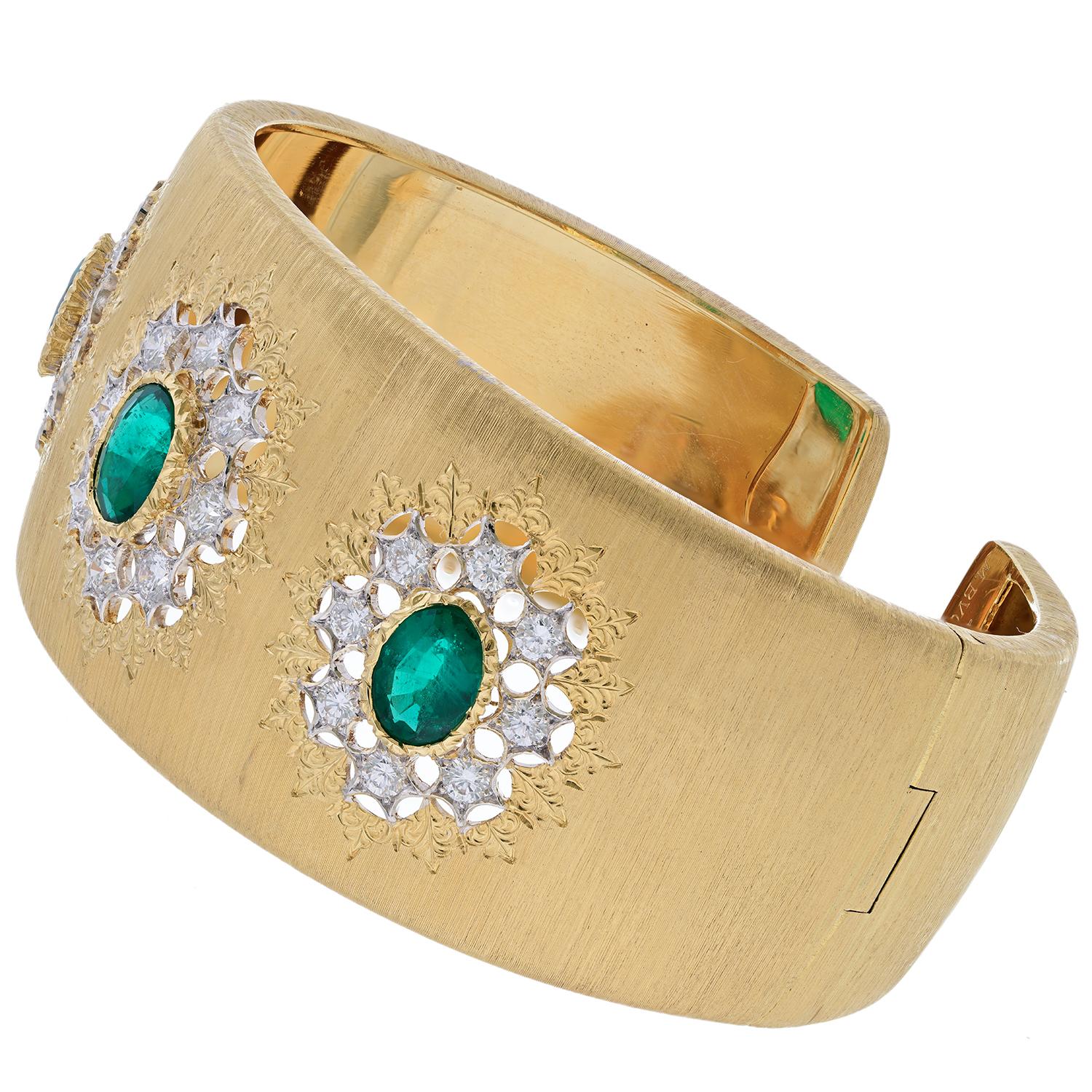 An exceptional emerald gem-set vintage 18k yellow gold and white gold cuff by Buccellati, circa 1980. Featuring three oval-shaped emeralds and framed by round diamonds, this bracelet is signed M. Buccellati, Italy, stamped 750 for 18 karat gold,