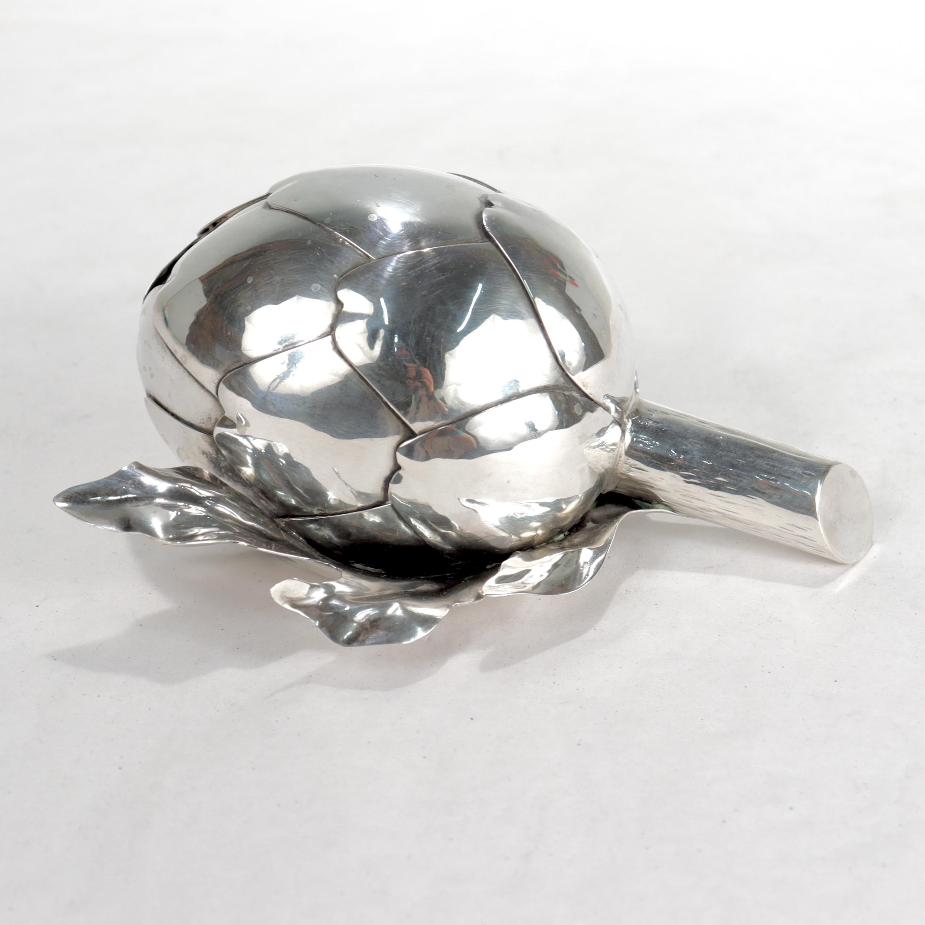 A fine figural table lighter.
 
In .800 fine silver. 

By Mario Buccellati.

In the form of a realistic artichoke complete with leaves, petals, and stem.

The lighter is detachable and fully removable from the artichoke (untested for functionality).