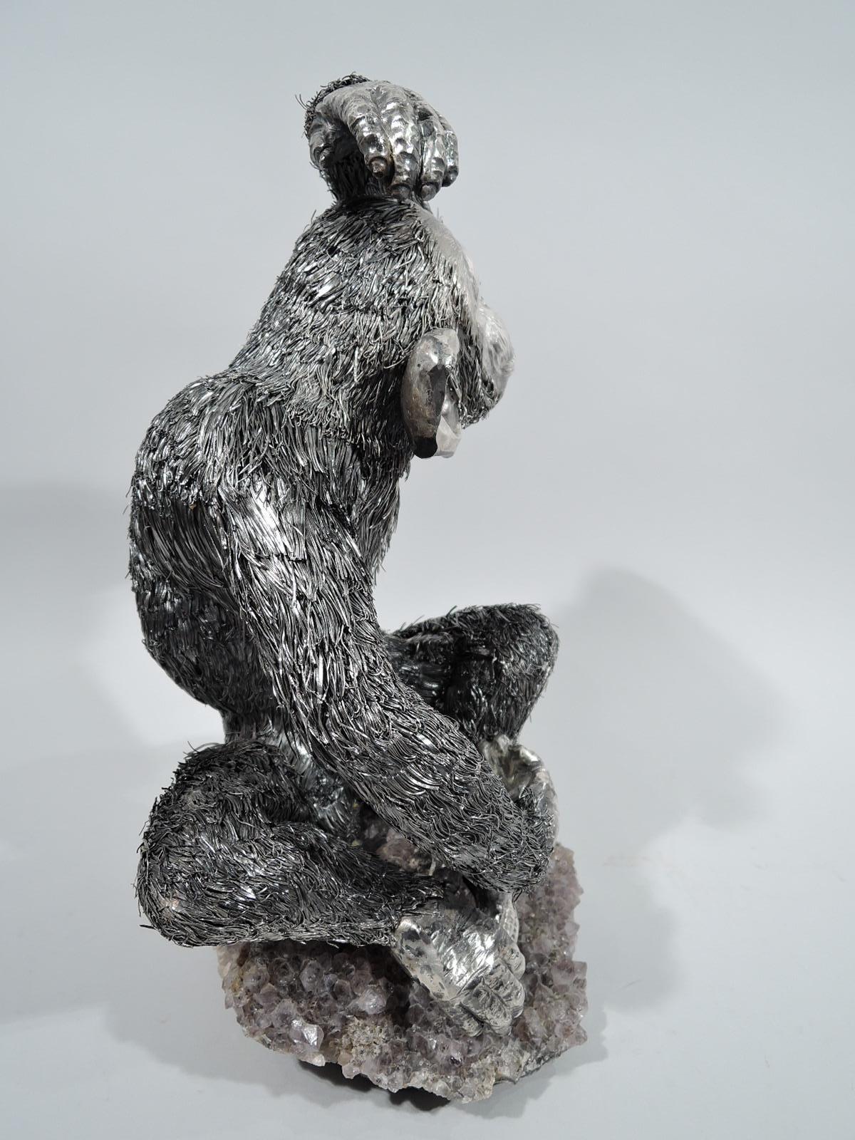Sensitive and endearing 800 silver animal figure. Made by Buccellati in Italy. A chimp with raised arm, big funny ears, and expressive face sits on amethyst crystal base with joined feet. A playful primate with tensile hands and feet, and shaggy