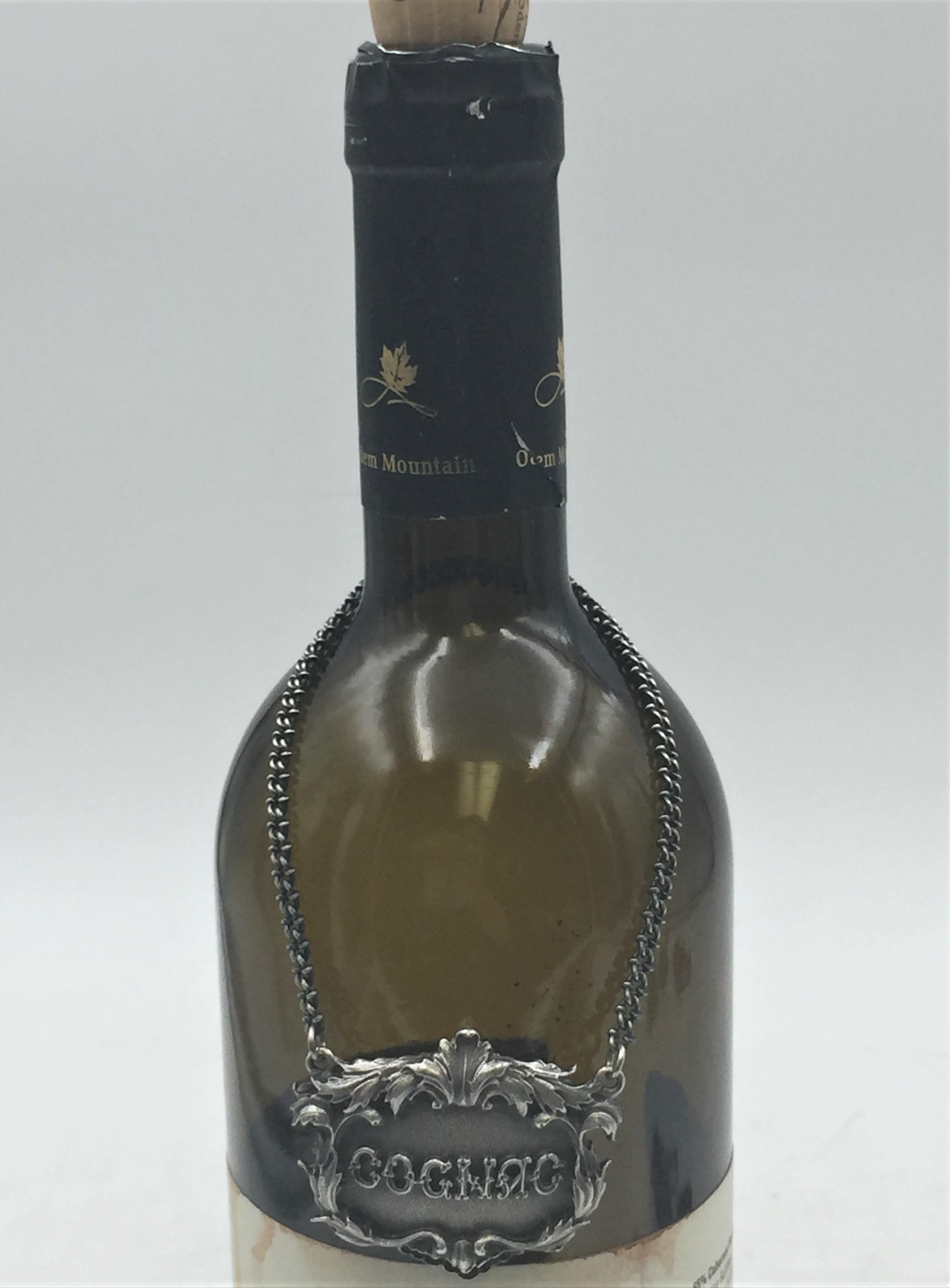 Rare Buccellati sterling silver claret bar jug label. COGNAC embossed on the front in the center.

Marks on the back: Gianmaria Buccellati (signature and Italian maker's mark), ITALY, 925 (encircled silver purity mark).

It measures 1.5in x 1.5in.