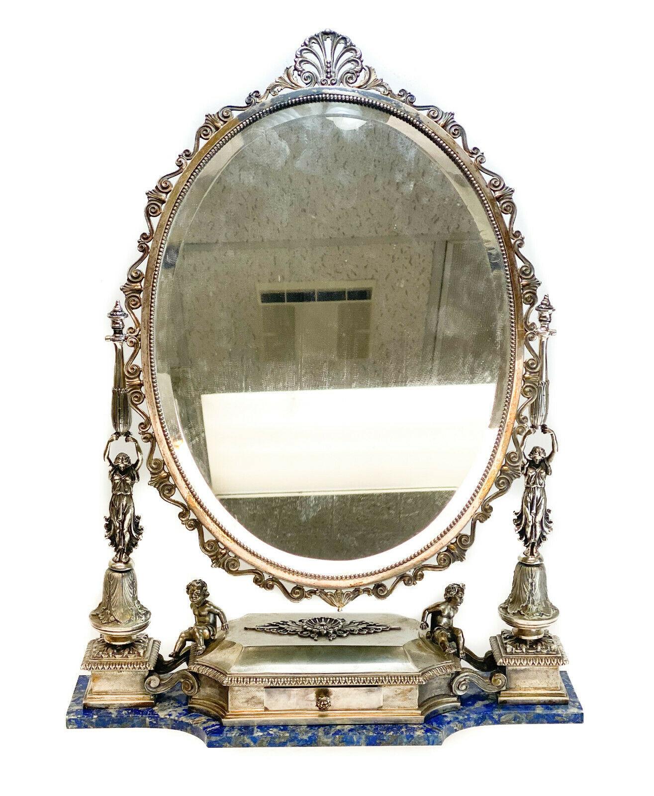 Buccellati Italian sterling silver and lapis lazuli vanity mirror, circa 1960. Figural beauties and cherubs to towards the base with hand chased foliate scroll and beaded accents around the rim. Velvet lining to the drawer and back of the mirror.