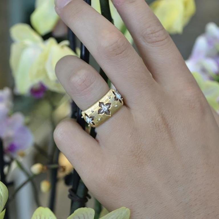 This Buccellati Macri Giglio Ring is in textured in 18 karat yellow gold with 6 brilliant-cut diamonds set in small 18 karat white gold star-shaped rosettes.

The ring is made in 18 karat yellow and white gold and engraved using the well-known