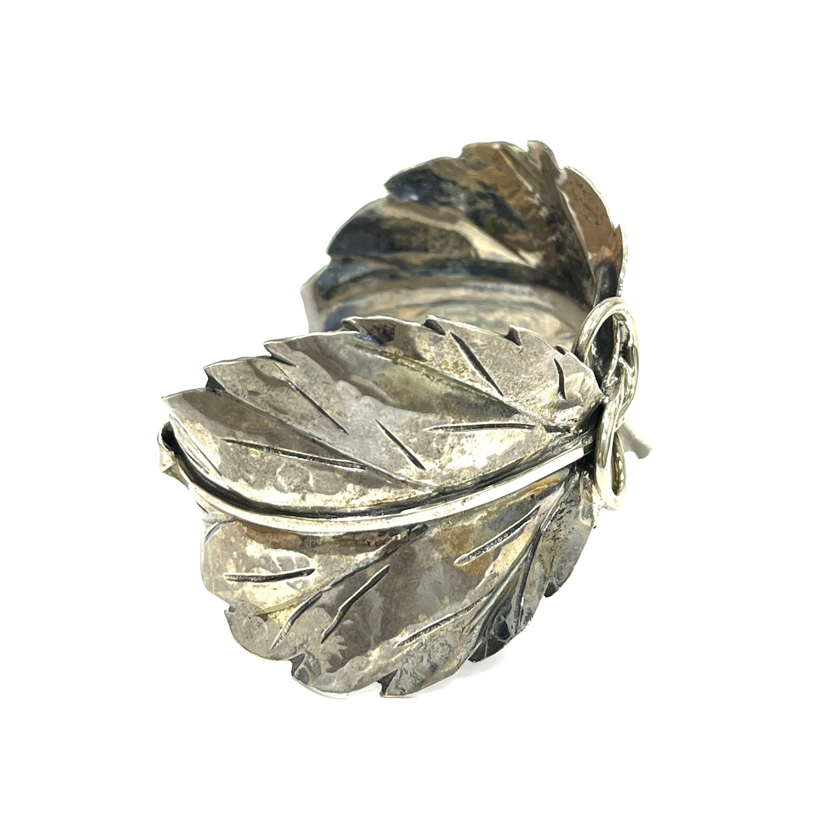 Buccellati Mario Leaf Sterling Silver Cuff Bracelet, Italian

Two apple leaves made out of sterling silver; marked Buccellati, Italy, 925, Sterling

Size: width 1.75 inches; inner circumference 6.5 inches
Total weight: 38.0 grams