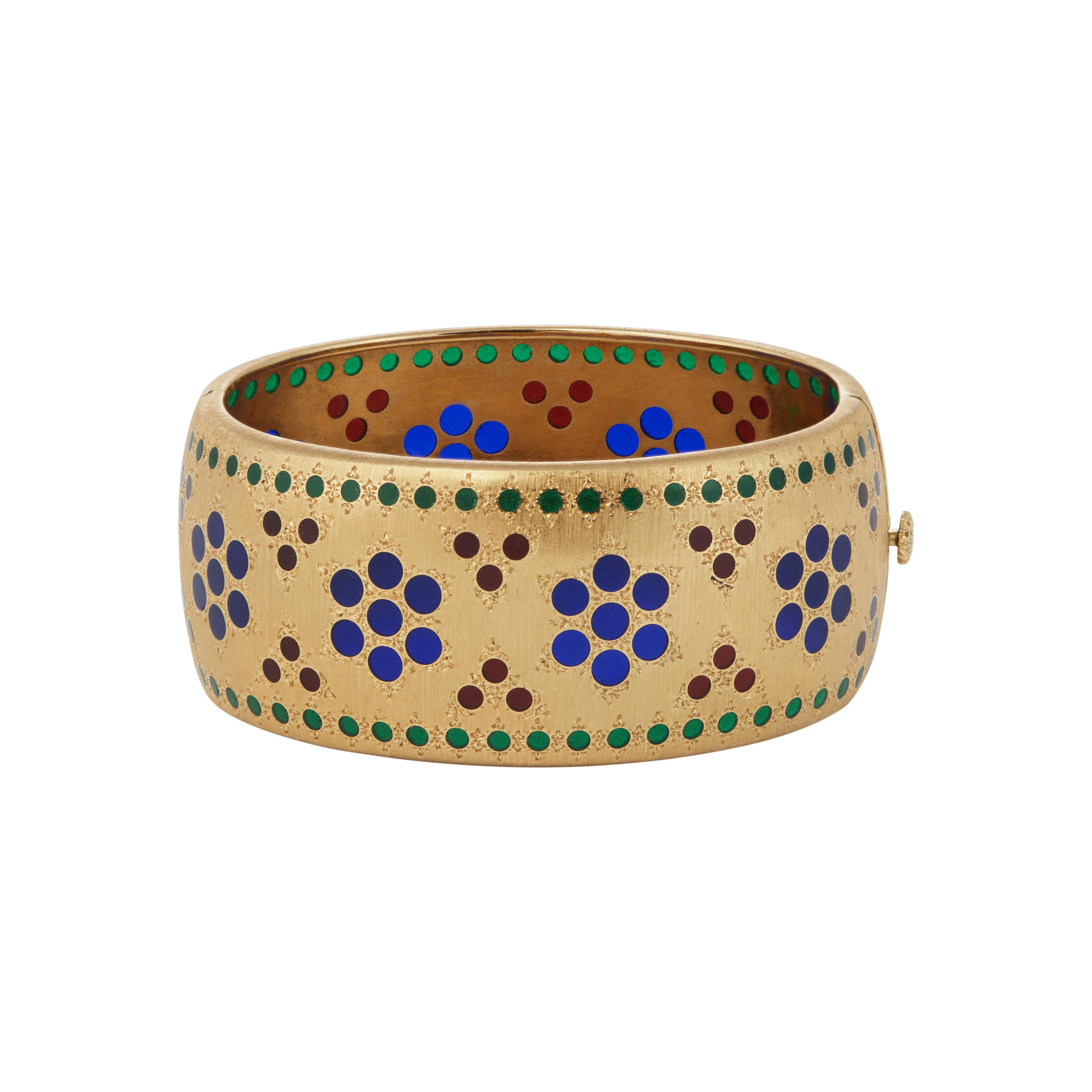 This Buccellati 18-karat yellow gold handmade bangle bracelet features a satin finish and plique-à-jour enamel,  delicately adorned in blues, reds, and greens. Made in Italy, the bracelet measures 6.25 inches in diameter and includes a hinged design