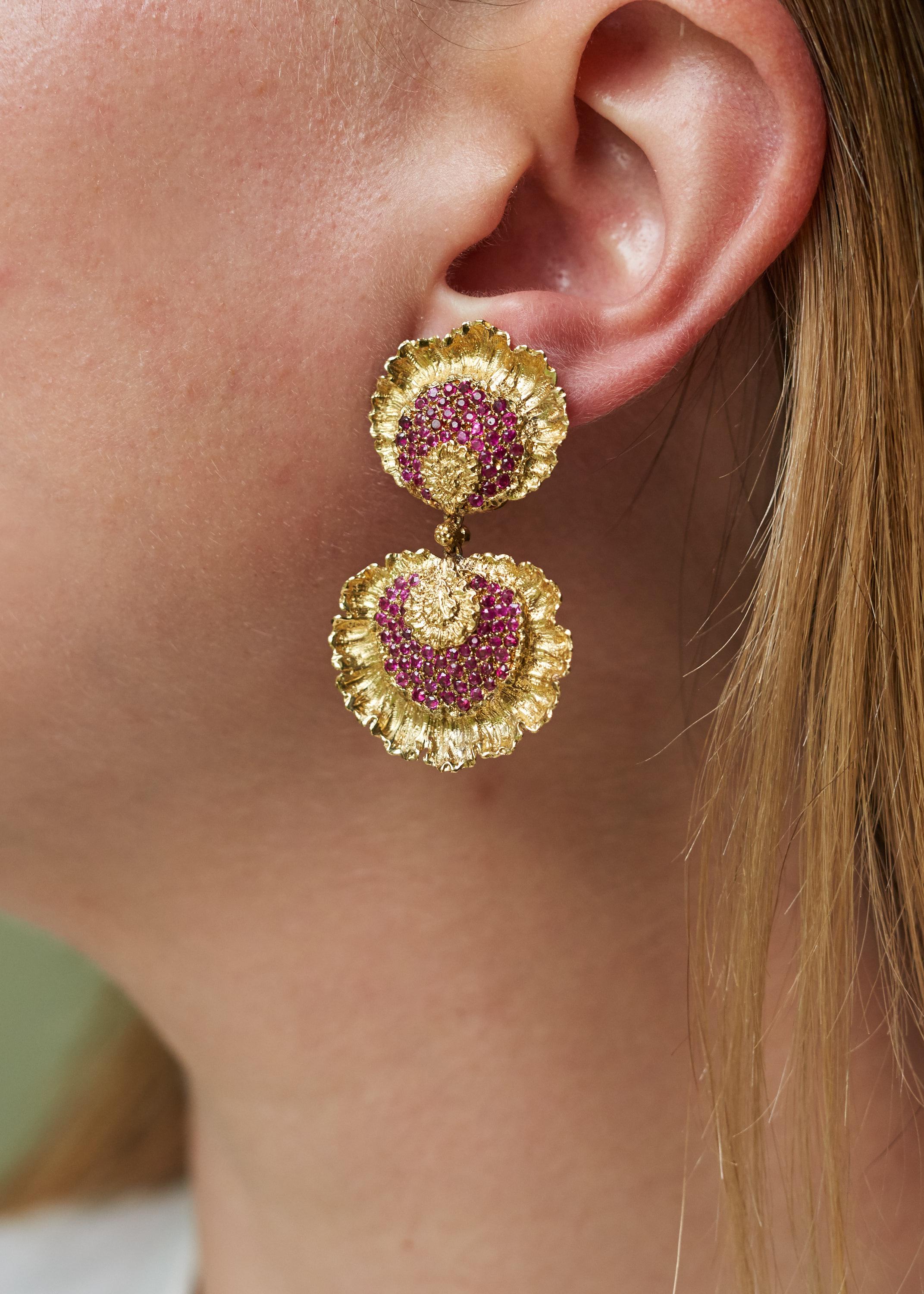 A pair of ruby and 18 karat gold clip on ear pendants, by Buccellati.  With original box. 

The earrings are signed Buccellati and stamped 750. 

Omega clip backs for non-pierced ears.