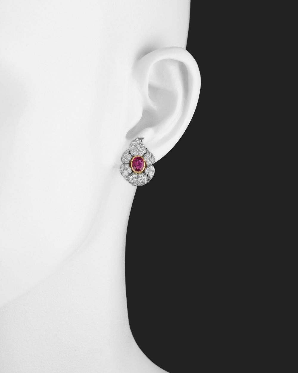 Ruby and diamond foliate cluster earclips, composed of two oval-shaped rubies weighing approximately 1.52 total carats, surrounded by circular-cut diamonds weighing approximately 1.90 total carats, one of the rubies set in 18k yellow gold and the
