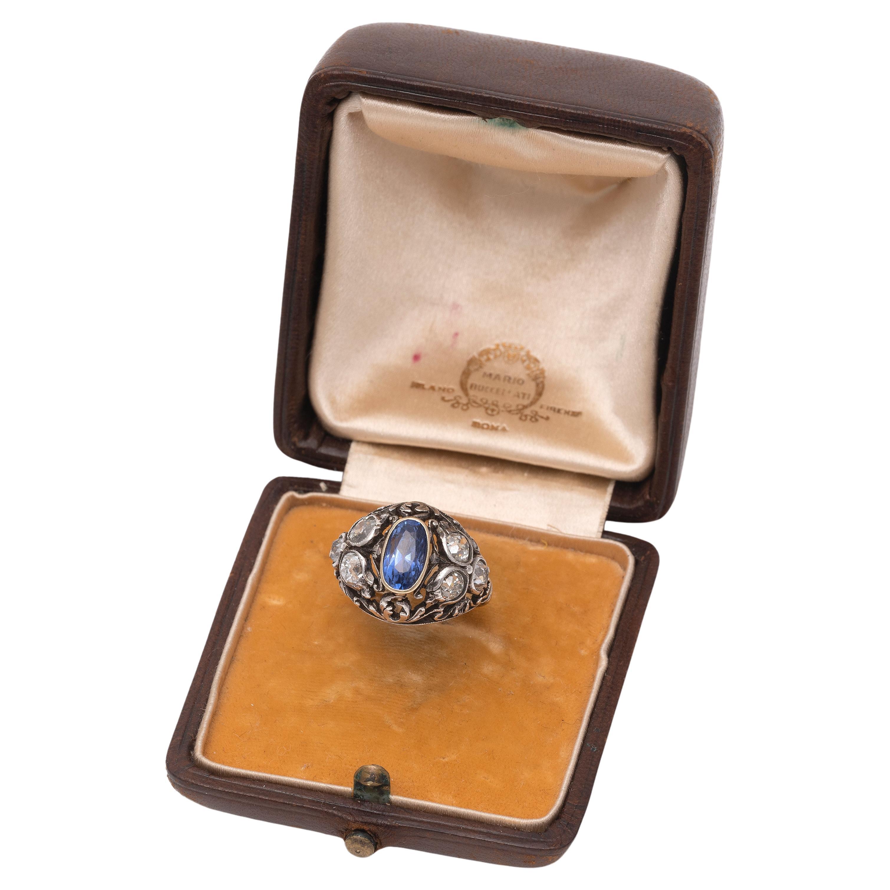 In gold and silver, with openwork motif depicting vines, embellished in the center with an oval-cut sapphire weighing approximately 1.90 ct, flanked by old-cut diamonds weighing approximately 1.50 ct, signed 