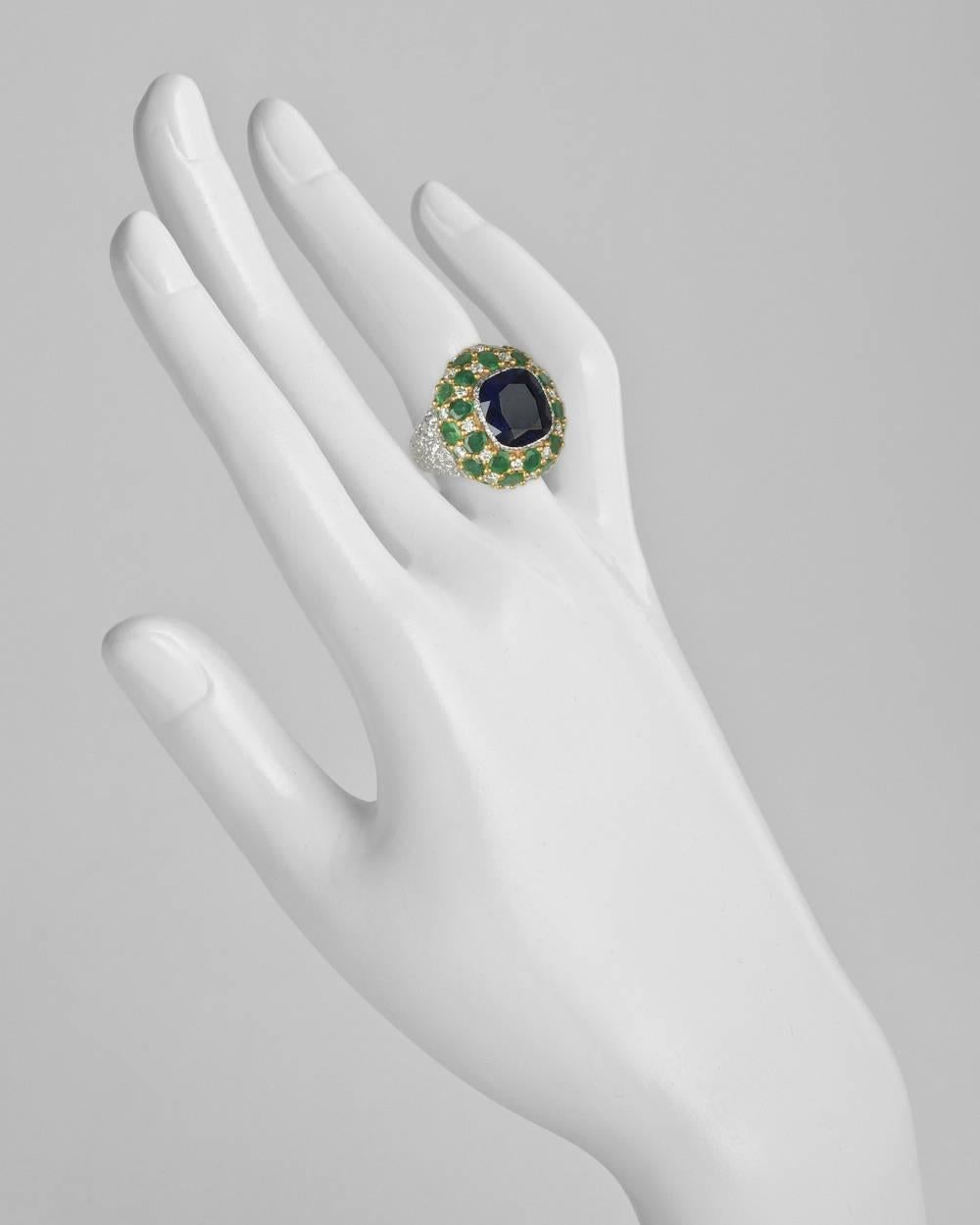 Cocktail ring, centering a cushion-shaped natural sapphire within a bombé-style mount of pavé-set emeralds and diamonds, in a textured 18k white gold setting with 18k yellow gold, signed Buccellati. Sapphire weighing approximately 8.00 carats,