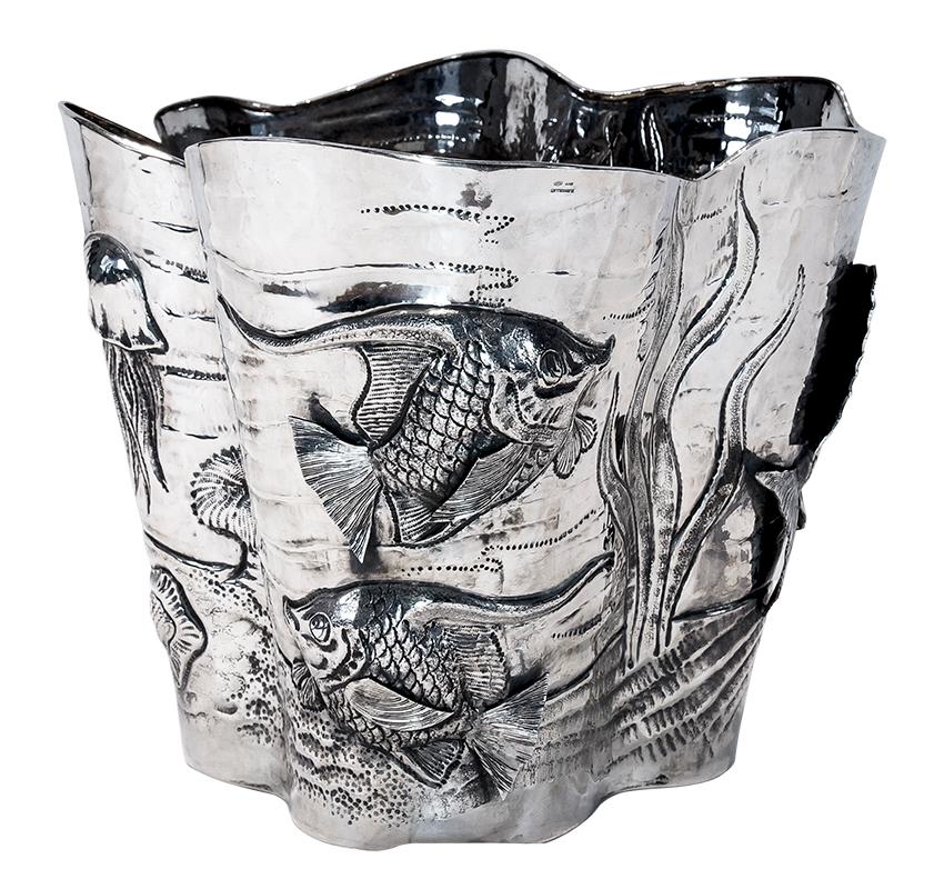Cubo de champán Buccellati con motivo marino en plata de ley.

Cubo de champán Buccellati, con motivos marinos. Vasija elevada de plata de ley, acabada con técnicas de persecución y repujado de diversas criaturas vistas en el fondo del océano.