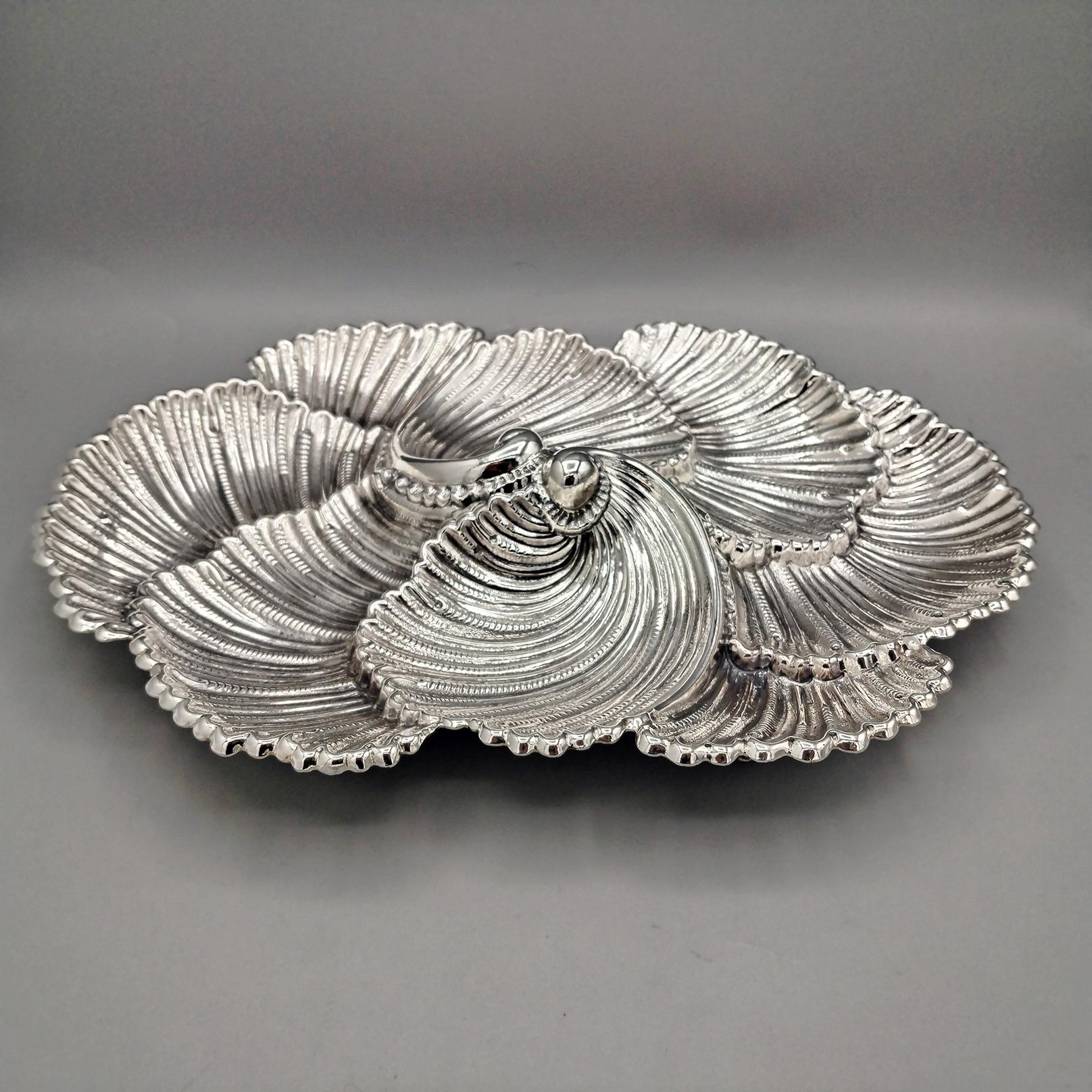 Shell-shaped centerpiece by Gianmaria Buccellati.
The centerpiece was embossed and chiseled entirely by hand, reproducing 8 sections of Arca shells that, when assembled, make the centerpiece prestigious and elegant.
4 shell-shaped feet, made with