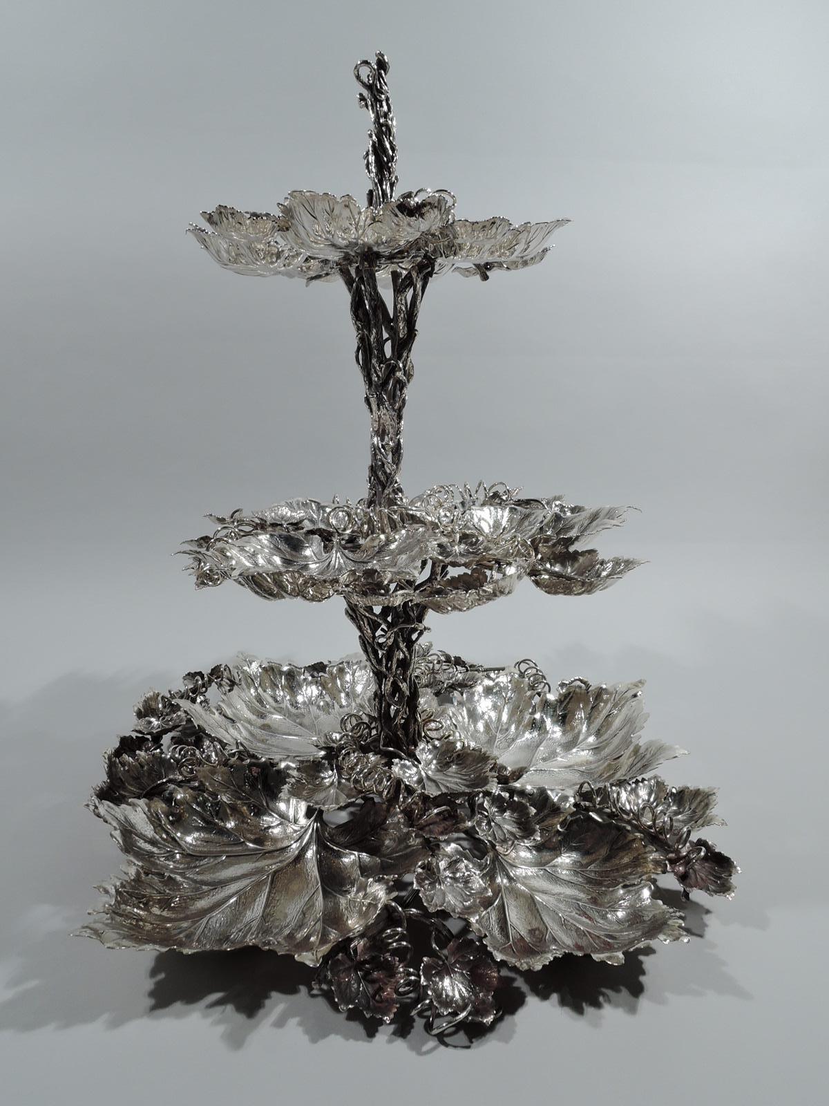 Woodsy sterling silver serving stand. Open and entwined branch shaft supporting 3 graduated tiers, comprising irregularly arranged leaves of various sizes and curlicue tendrils. A show-stopping greenery-silvery centerpiece. Marked “Buccellati /