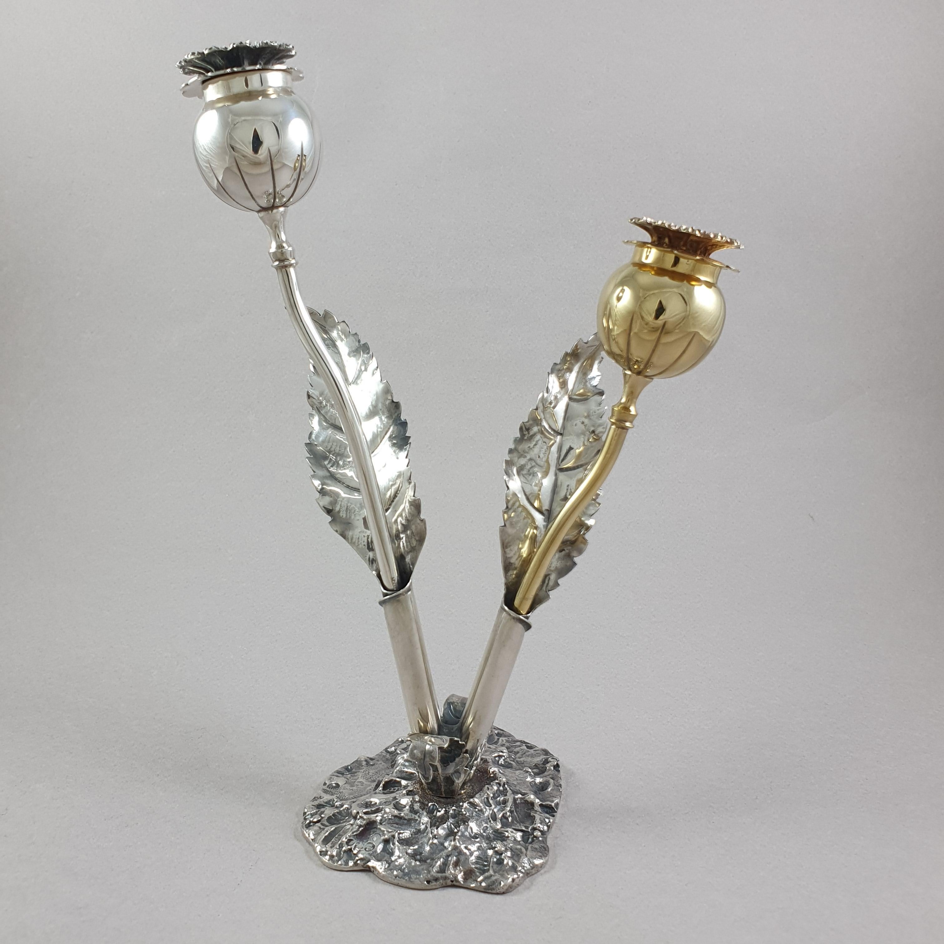 Stylish sterling silver figural salt and pepper shakers. Two flowers set in stand. Each flower has a curvilinear stem, round bud with threaded double-leaf cover (bottom leaf pierced). Cast stand has two holders in form of wrapped leaves rooted in