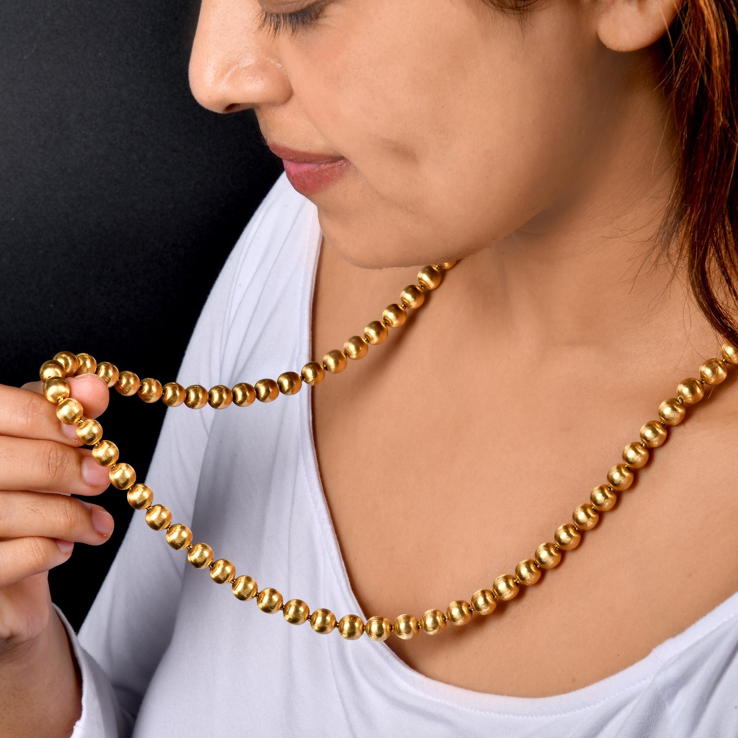 Ce collier exquis et intemporel en or massif 18 carats de Buccellati date des années 1980. Mesurant 28 pouces de long, chaque perle de 8 mm de large présente un magnifique travail de finition satinée gravé à la main, illustrant le savoir-faire