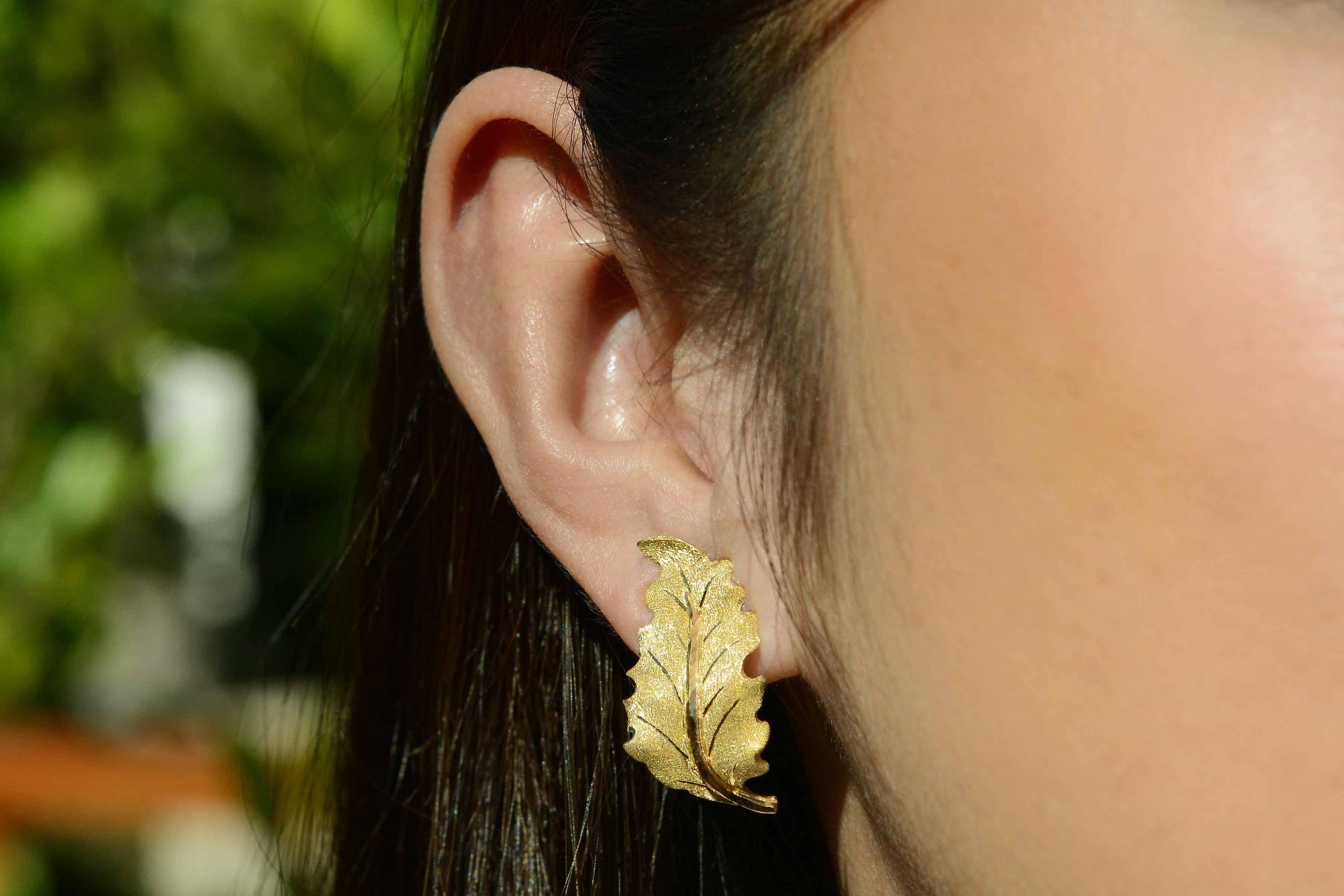 Exceptionnelle paire de boucles d'oreilles en or jaune 18 carats finement détaillées. La tige satinée est délicieusement contrastée par des feuilles d'or ressemblant à du givre et présentant l'effet de gravure caractéristique de la marque.