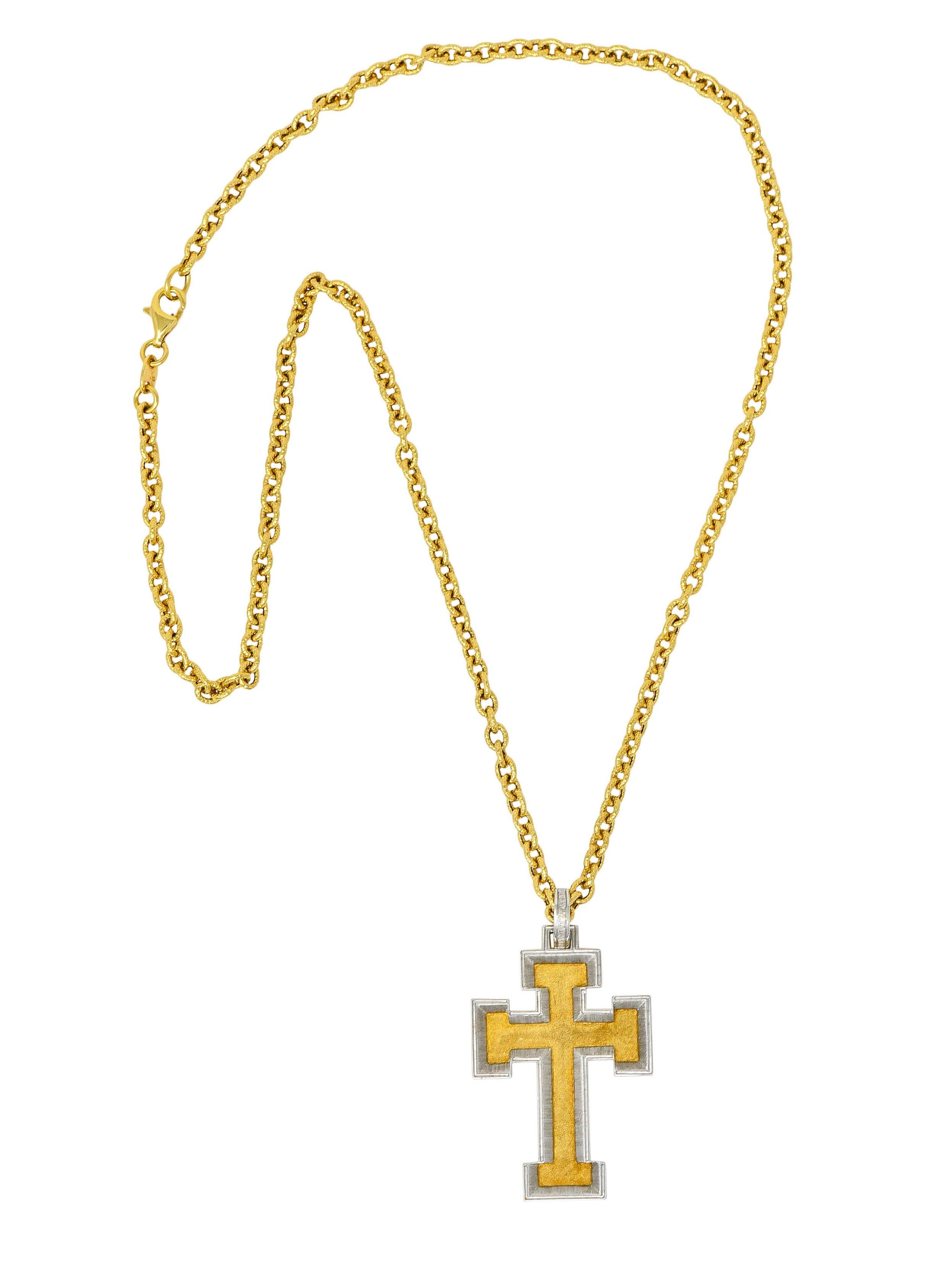 Stylized cable chain necklace is comprised of textured links and completes as a lobster clasp

Suspending a matte two-tone gold cross with chamfered white gold edges leading to a yellow gold center

Featuring a strong brushed and stippled finish