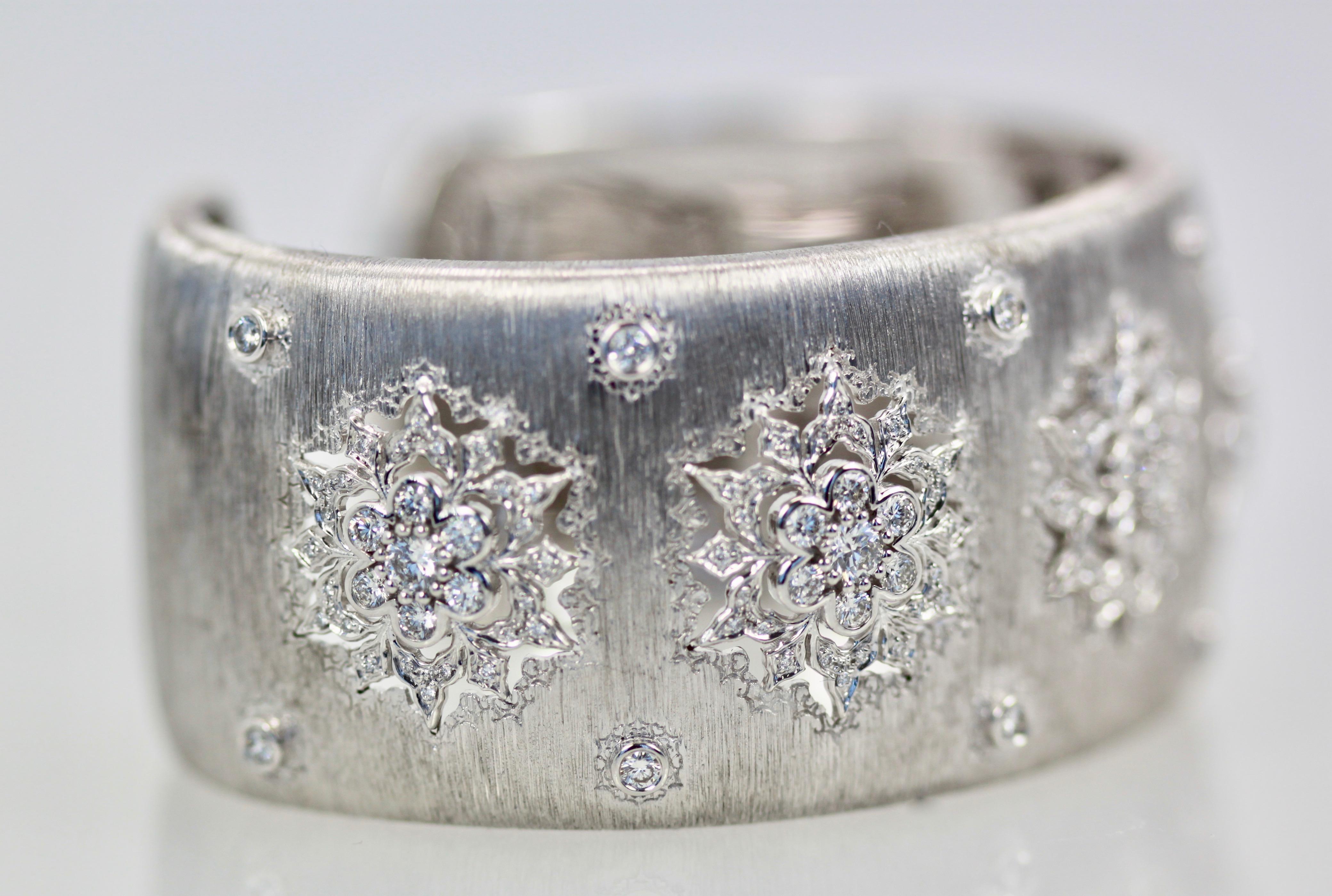 This White Gold Buccellati Wide Bracelet is covered in Diamonds with a total of 5 Carats and it is brushed detailed gold.  There are 5 snowflake detailed and cut out as lace and is filled with Diamonds.  The Diamonds are color F and clarity VS1 and