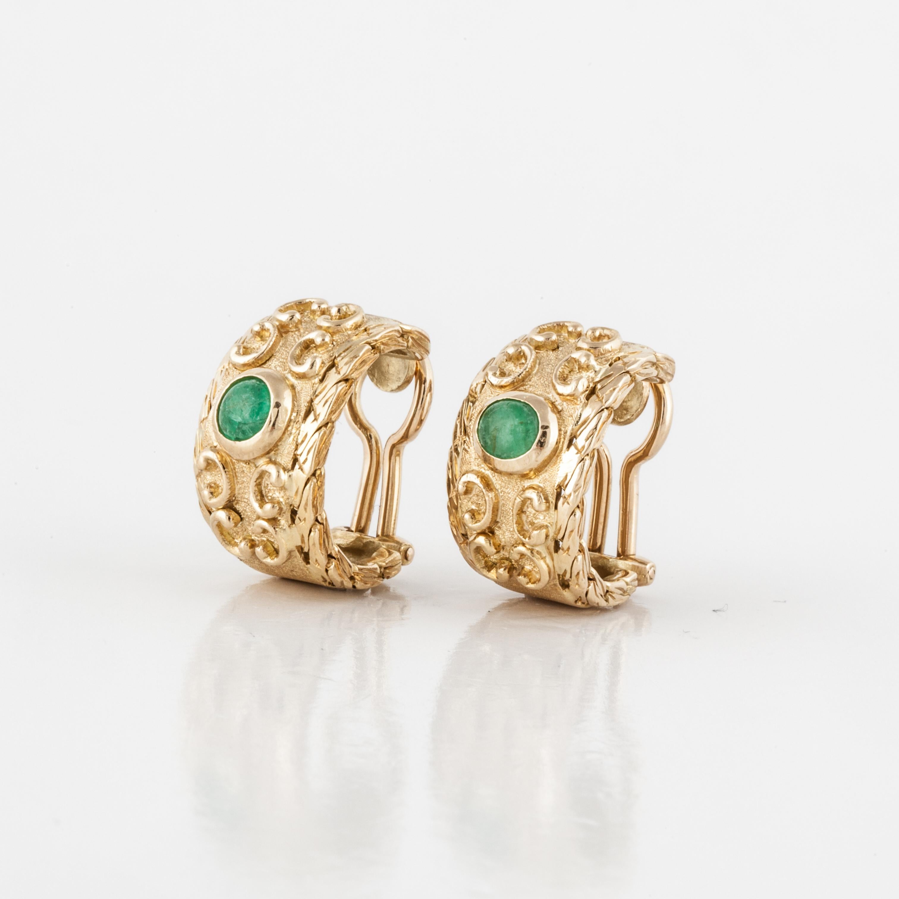 Buccellati semi hoop earrings in 18K yellow gold, with scroll work and cabochon emeralds set in the center.  There are two cabochon emeralds that total 1 carat.  Marked 