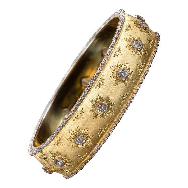 Yellow gold is finely hand-engraved in a fabric-like texture to create Buccellati’s famed Florentine finish. This 18k gold bangle is decorated with full cut diamond melee set in 14k white gold with starburst engraving.  

- Inside circumference