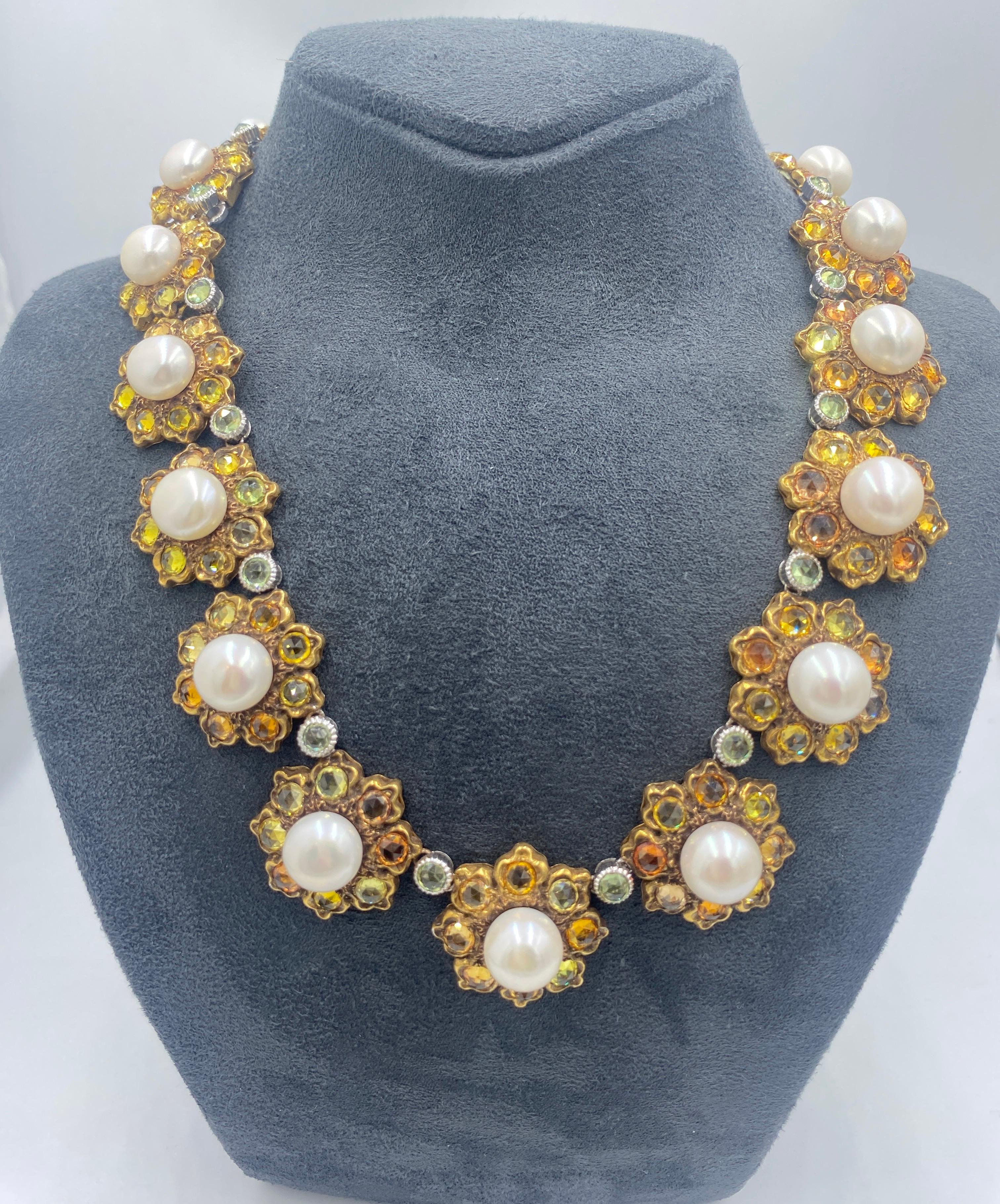 This magnificent 18 carat gold necklace designed by Gianmaria Buccalleti in 1980s consists of 18 floral links. Each flower has a large pearl in its centre and various shades of yellow sapphires as its 8 petals. The flowers are linked together by