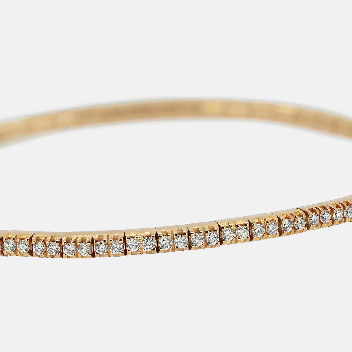 Ecco uno squisito bracciale realizzato dal rinomato designer di gioielli svizzero Bucherer. Questo pezzo contemporaneo è realizzato in ricco oro rosa 18ct e forma una fascia elegante e flessibile. Presenta una linea continua di 118 diamanti bianchi