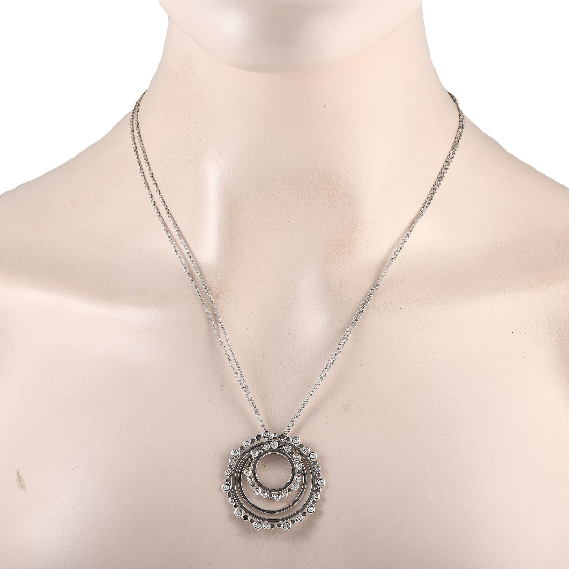 Un bijou polyvalent que vous pourrez porter à maintes reprises. Ce collier en or blanc de Bucherer est composé d'une double chaîne de 30 pouces de long portant un pendentif rond à cercles concentriques. Le pendentif de 1,5 pouce de large présente