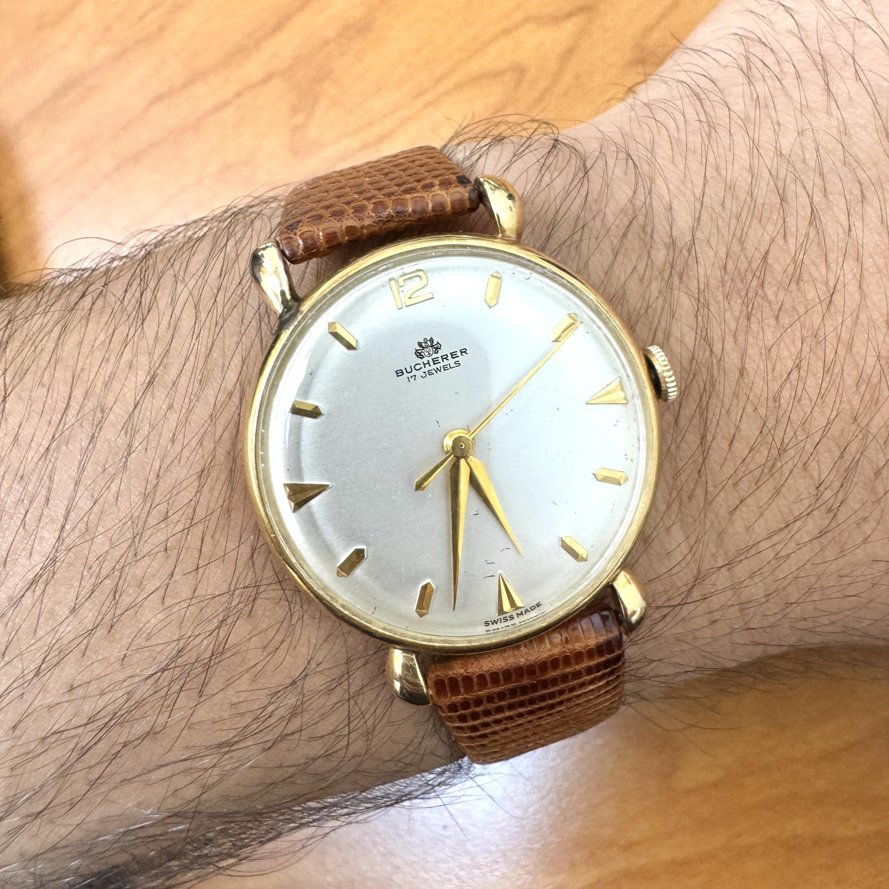 A vintage classic 33mm Bucherer reference 50030, 17 jewels, watch featuring a manual wind movement and 18K yellow gold case. Comes with a brown genuine leather lizard strap. Swiss Made.

The strap and buckle are not Bucherer.

Details:
Item Type: