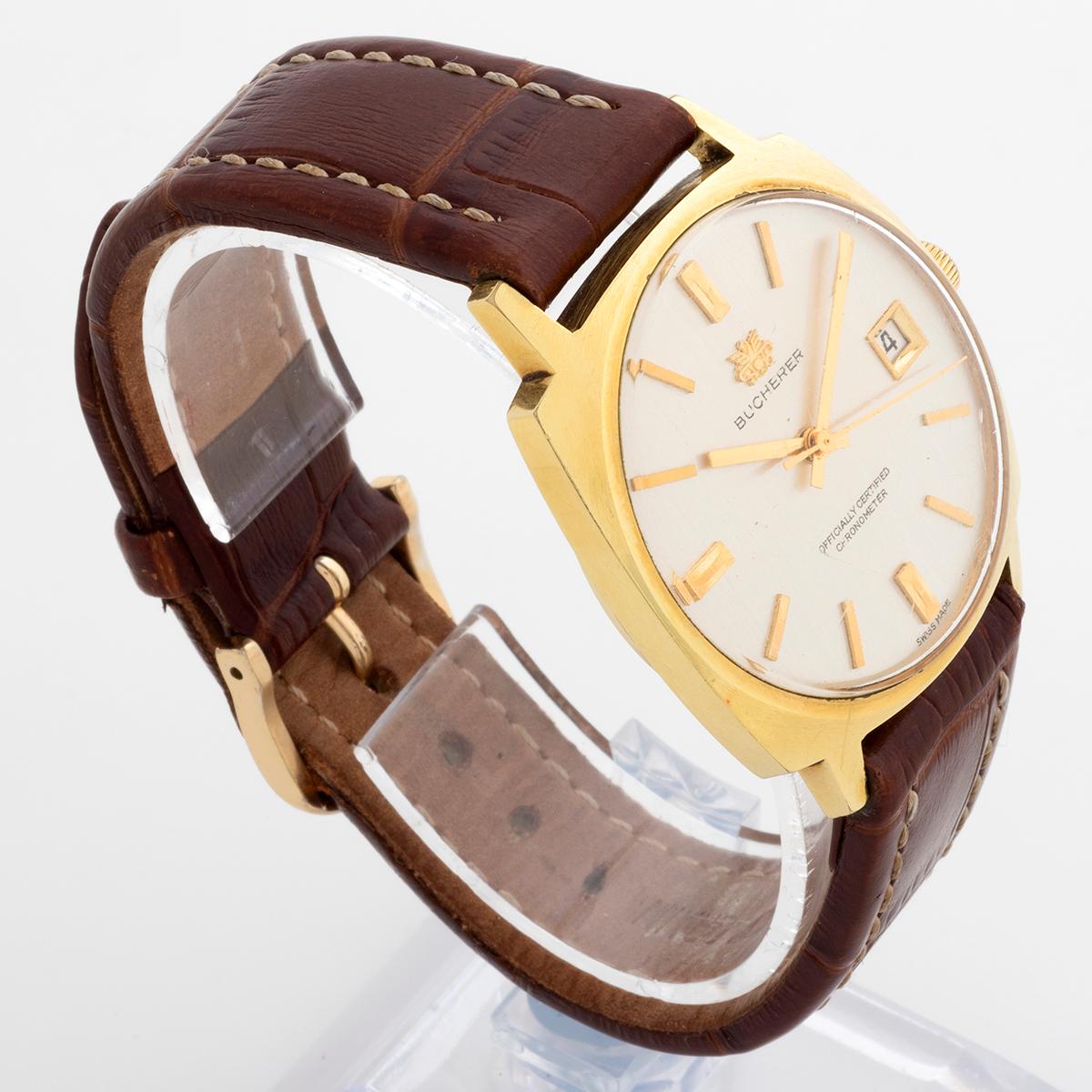 Cette montre automatique Bucherer est dotée d'un boîtier en acier inoxydable recouvert d'or de 25 mm avec la couronne, de 40,5 mm de long, d'un fond de boîtier vissé, d'un cadran en plexiglas avec le logo Bucherer appliqué et d'un chronomètre