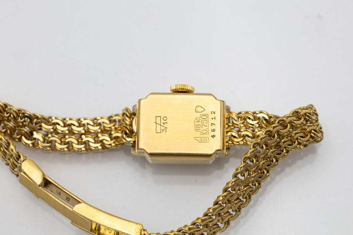 Women's gold watch by the renowned Swiss brand Bucherer with diamonds.

Origin: Switzerland, 1960s

Watch on a bracelet made of double chains of 18-karat gold.

The white dial in the case measuring 19x13mm made of 18-karat gold is decorated with 12