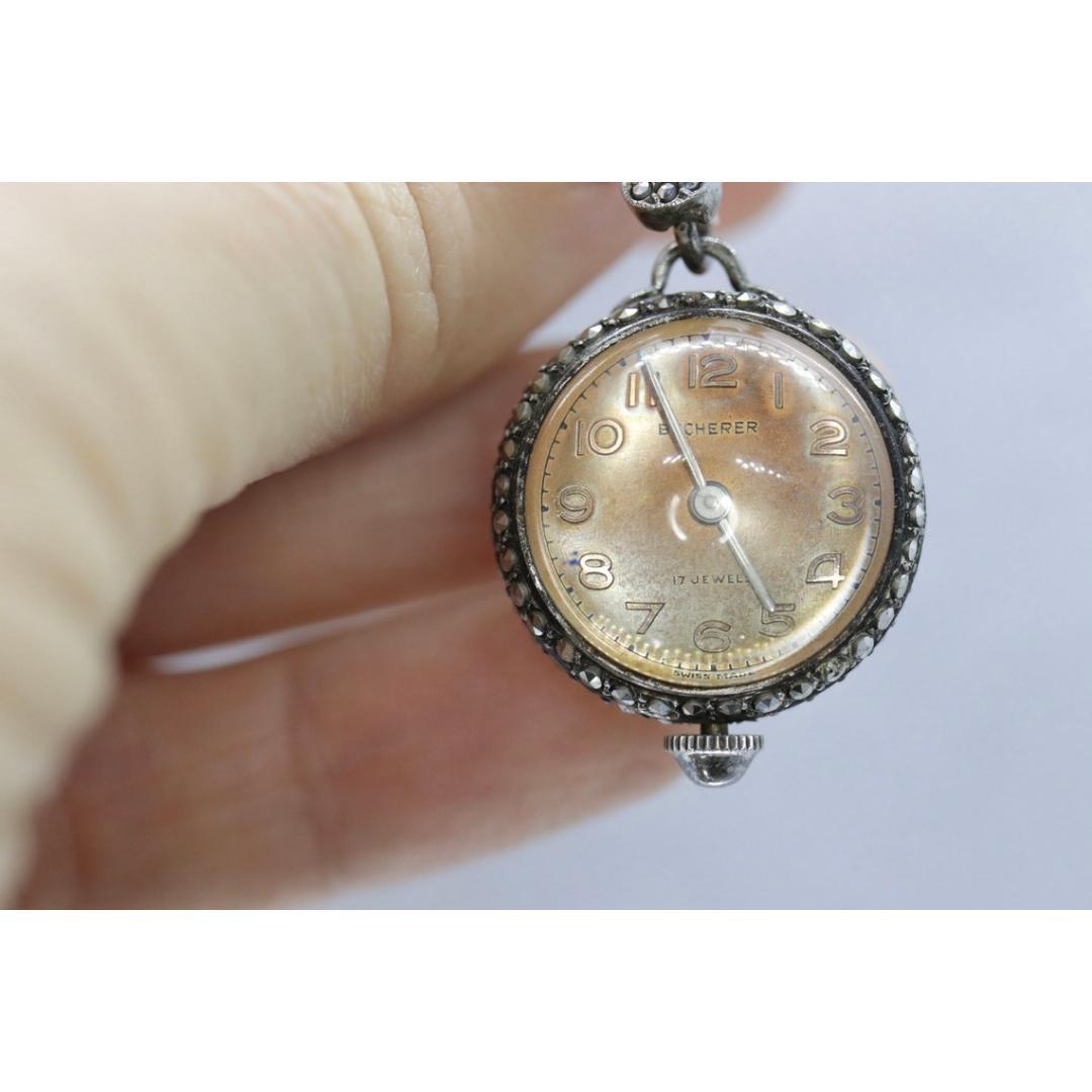 Vintage from the 1960s
Materials: Silver
Power: Mechanical

Readout: Analog

Very unique watch. Round Bubble watch hanging from a brooch/pin. Made by Bucherer. Case and brooch are sterling silver set with marcasite.

Condition: Sterling has vintage