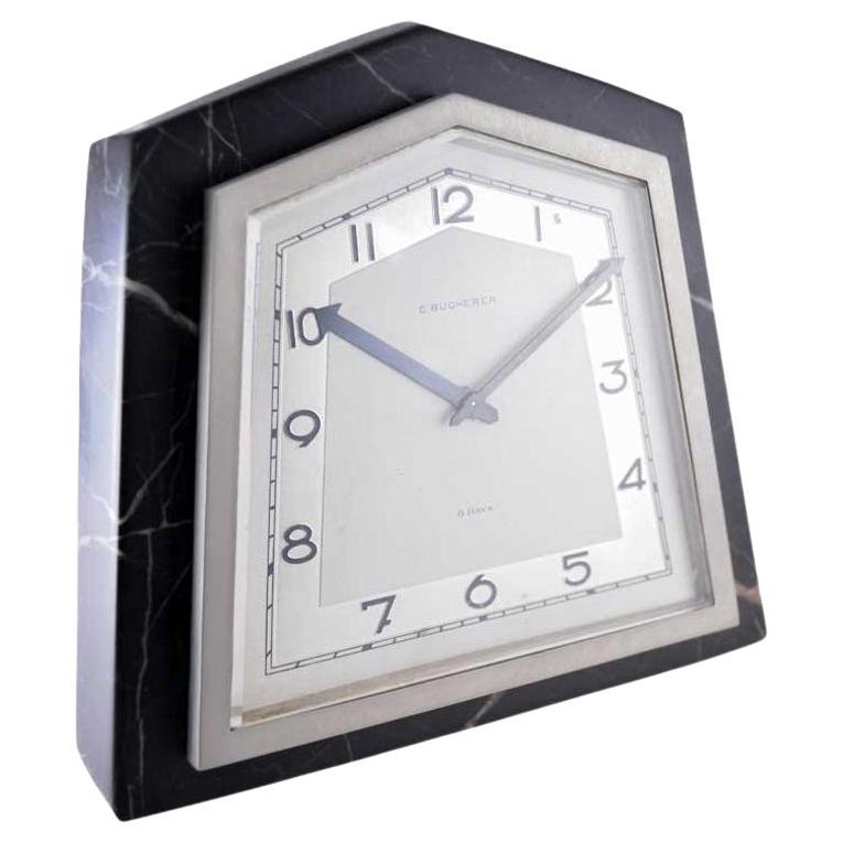 FACTORY / HOUSE: Bucherer Jewelers
STYLE / REFERENCE: Art Deco Desk Clock
METAL / MATERIAL: Stone and Nickel Finished Metal
CIRCA / YEAR: 1930's
DIMENSIONS / SIZE: 6 Inches X 6 Inches
MOVEMENT / CALIBER: Manual Winding / 15 Jewels 
DIAL / HANDS: