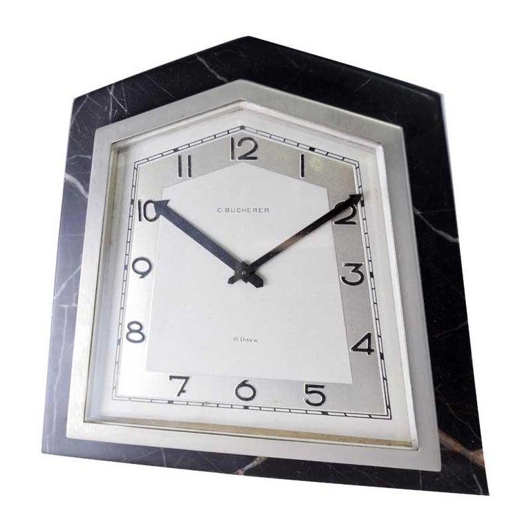 FACTORY / HOUSE: Bucherer Jewelers
STYLE / REFERENCE: Art Deco Desk Clock
METAL / MATERIAL: Stone and Nickel Finished Metal
CIRCA / YEAR: 1930's
DIMENSIONS / SIZE: 6 Inches X 6 Inches
MOVEMENT / CALIBER: Manual Winding / 15 Jewels 
DIAL / HANDS: