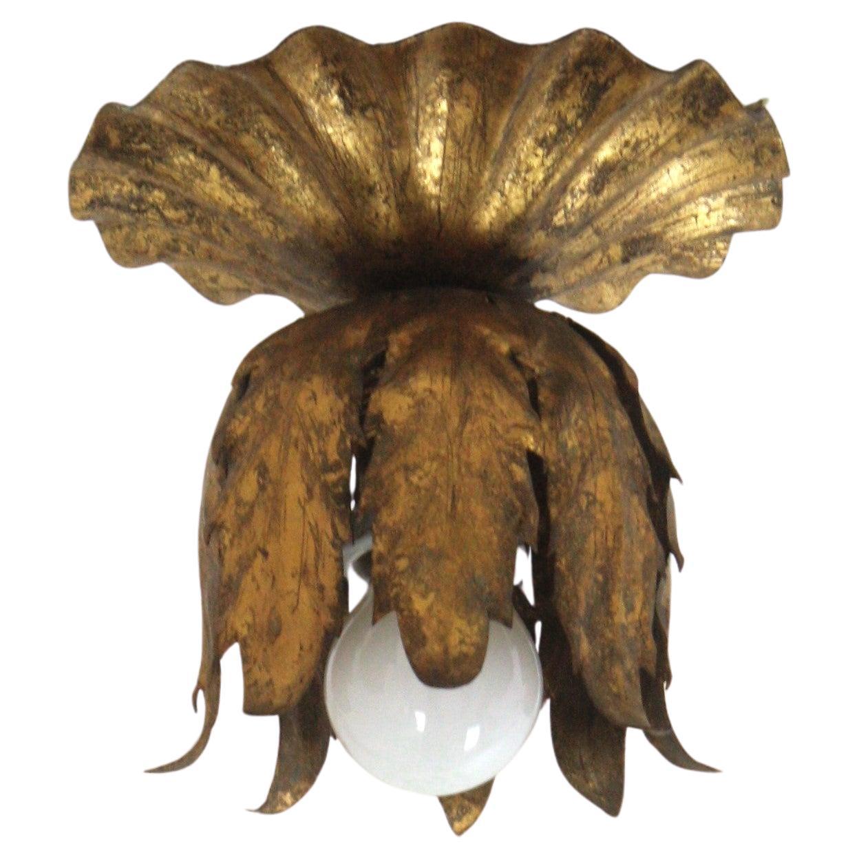 Flower bud flush mount, gold leaf, gilt iron. Spain, 1950s.
This handwrought iron ceiling light fixture has a terrific aged patina showing its original gold leaf gilding.
It can be used as a flush mount, as a wall light but also as a pendant hanging