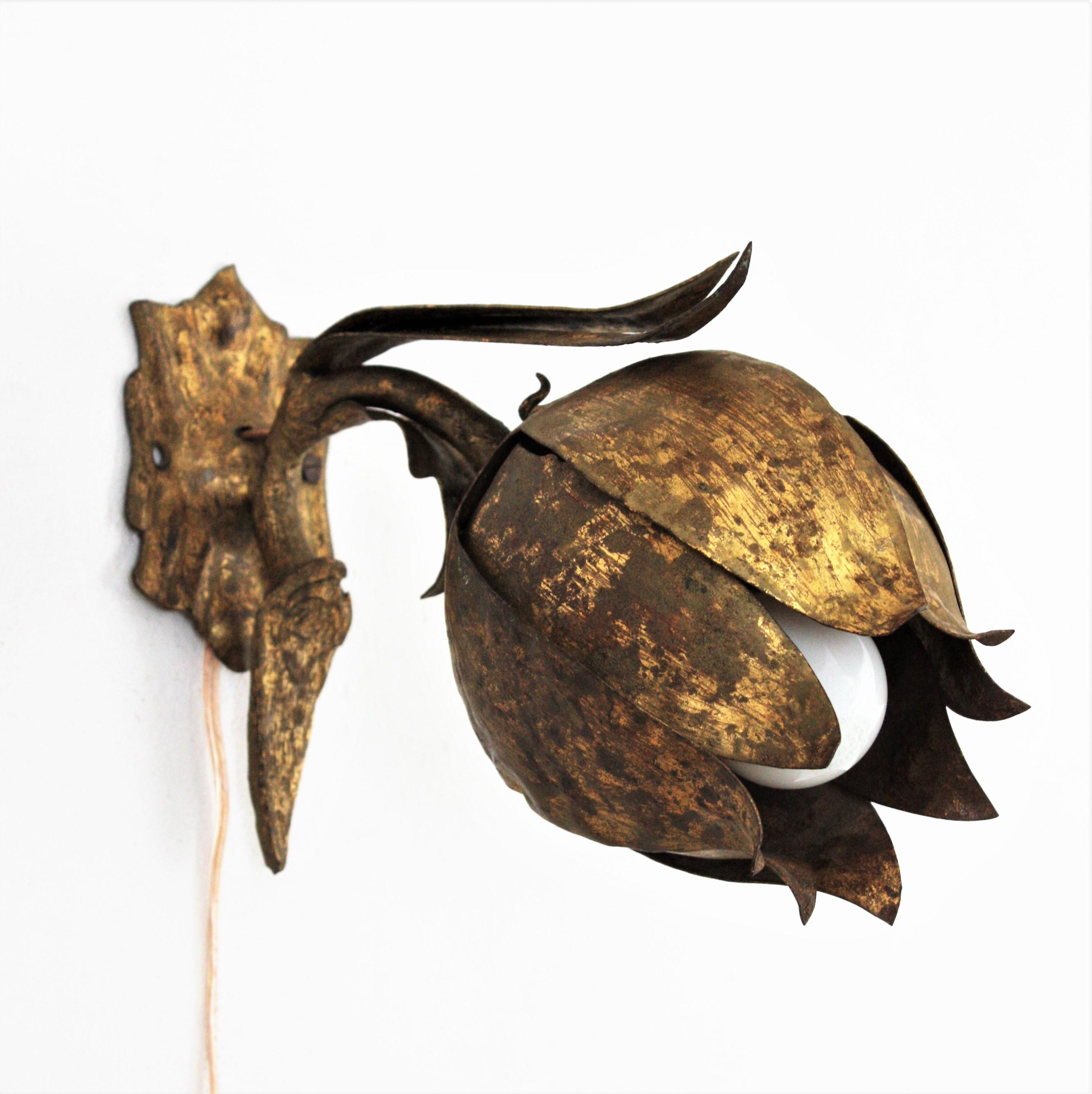 Flower Bud Wall Light, Gold Leaf, Gilt Iron. France, 1940s-1950s
This handwrought iron wall light features a flower bud with leaves. It has a terrific aged patina showing its original gold leaf gilding.
This floral wall sconce will be an elegant