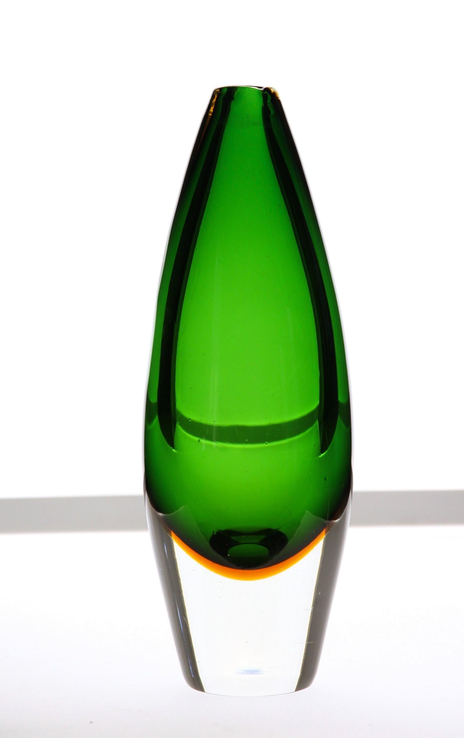 Elegant bud vase in sommerso colors.
Core is in green (could be aquamarine) with an amber casing and a massiccio clear base.
Mouth is spacco naturale, where the breaking point is left natural and rounded with a scalda (reheating to seal).
No
