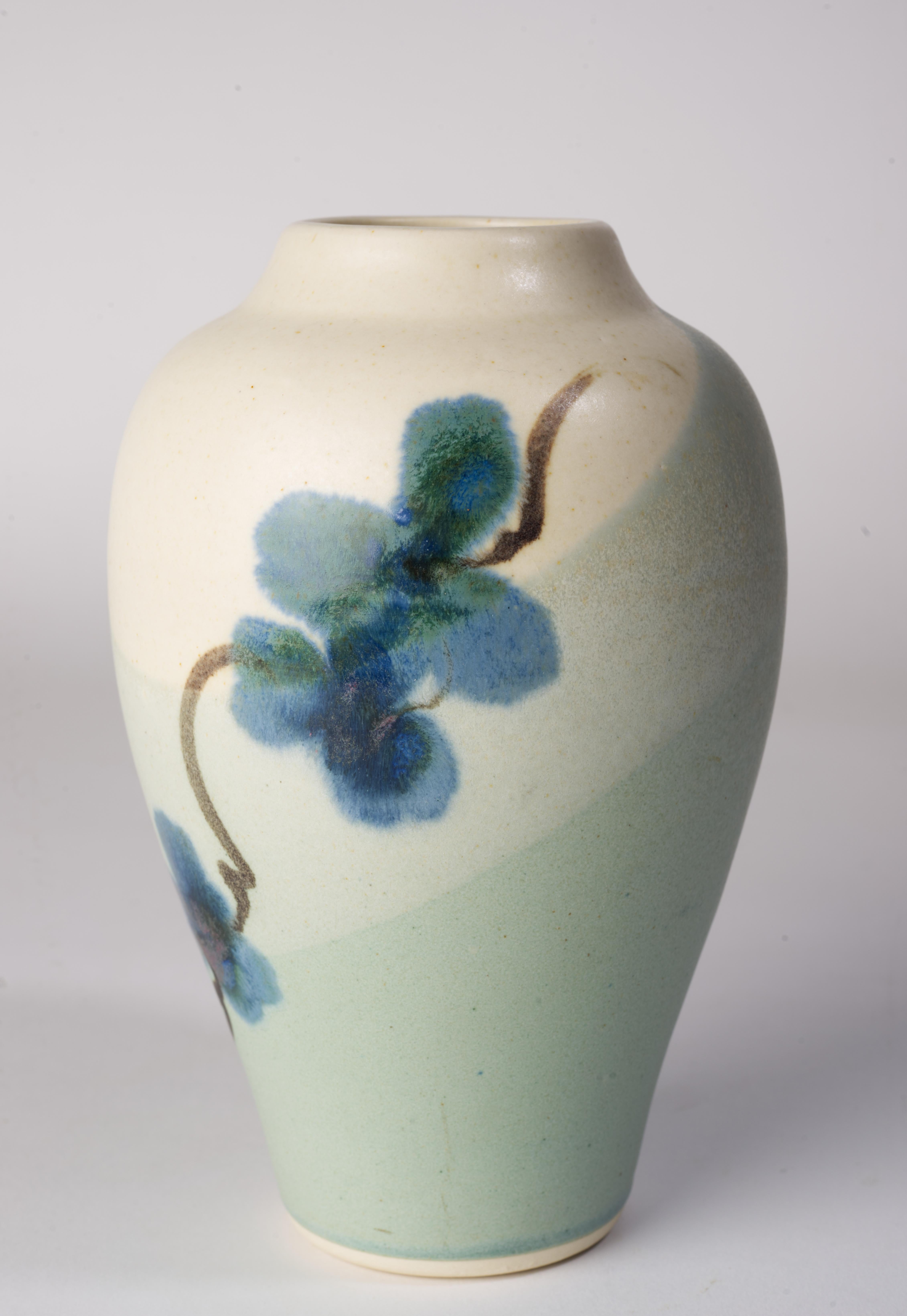  Vintage ceramic bud vase was made by Kent Follette in minimal, organic modern style. The vase is decorated with abstract flower design in various shades of blue with brown stems; the background is done in semi-matte light beige and blue glaze.