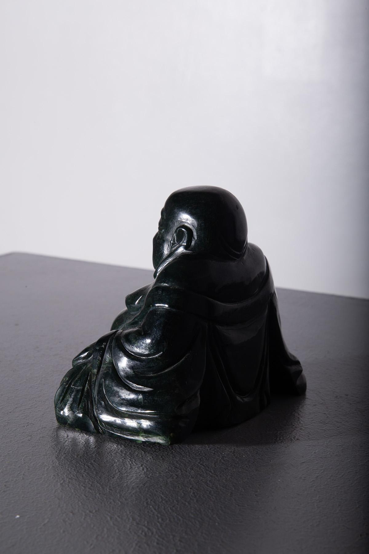 This exquisite dark jade Budai, also known as the Laughing Buddha, is a cherished symbol of happiness, prosperity, and abundance in Chinese Buddhist iconography. The figure of Budai, often depicted with a joyful smile and a round, protruding belly,