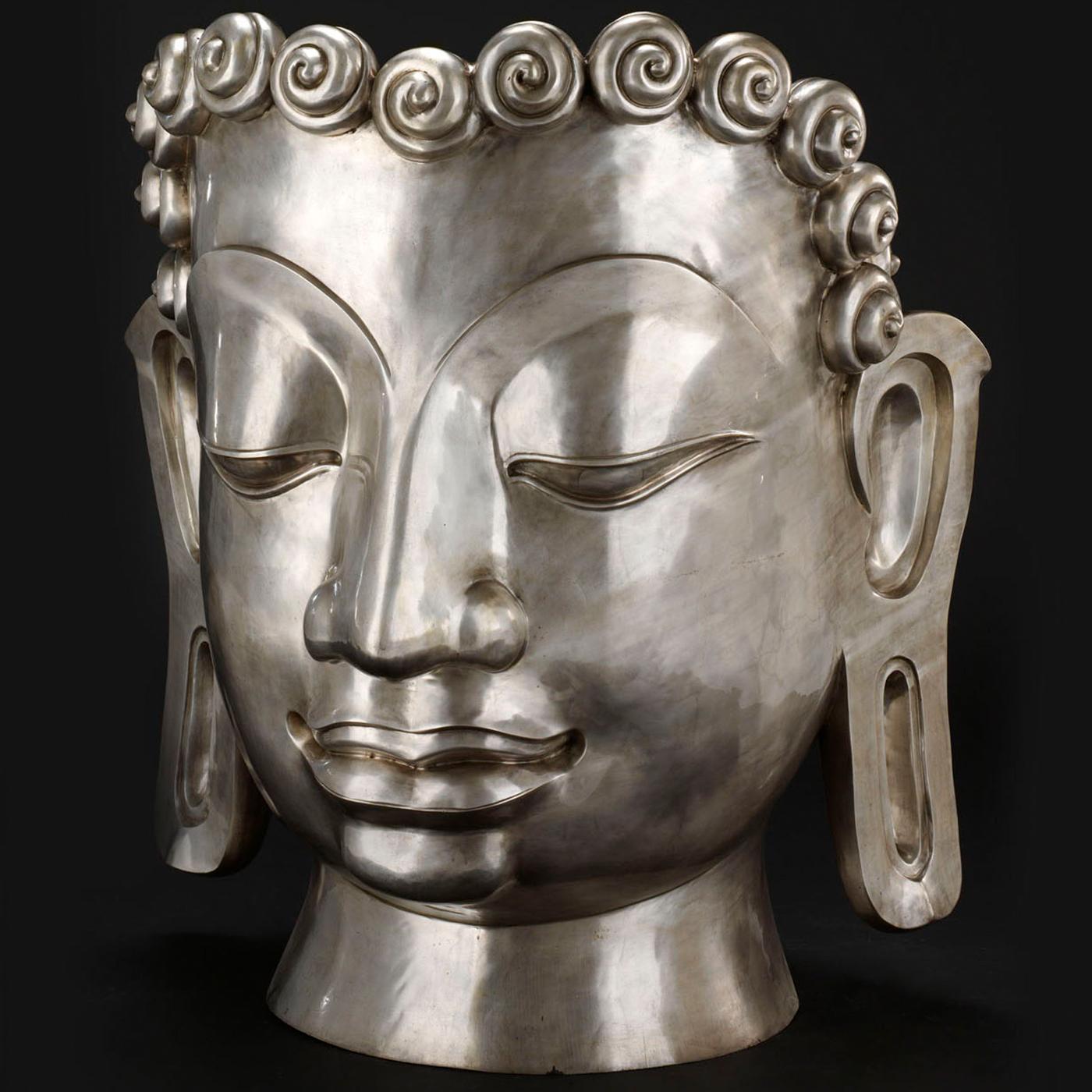 A superb showcase of deft craftsmanship, this objet d'art is masterfully handmade of molten bronze using traditional, age-old techniques. Reproducing the elegant likeness of Buddha with closed eyes, this mask features a crown of little roses