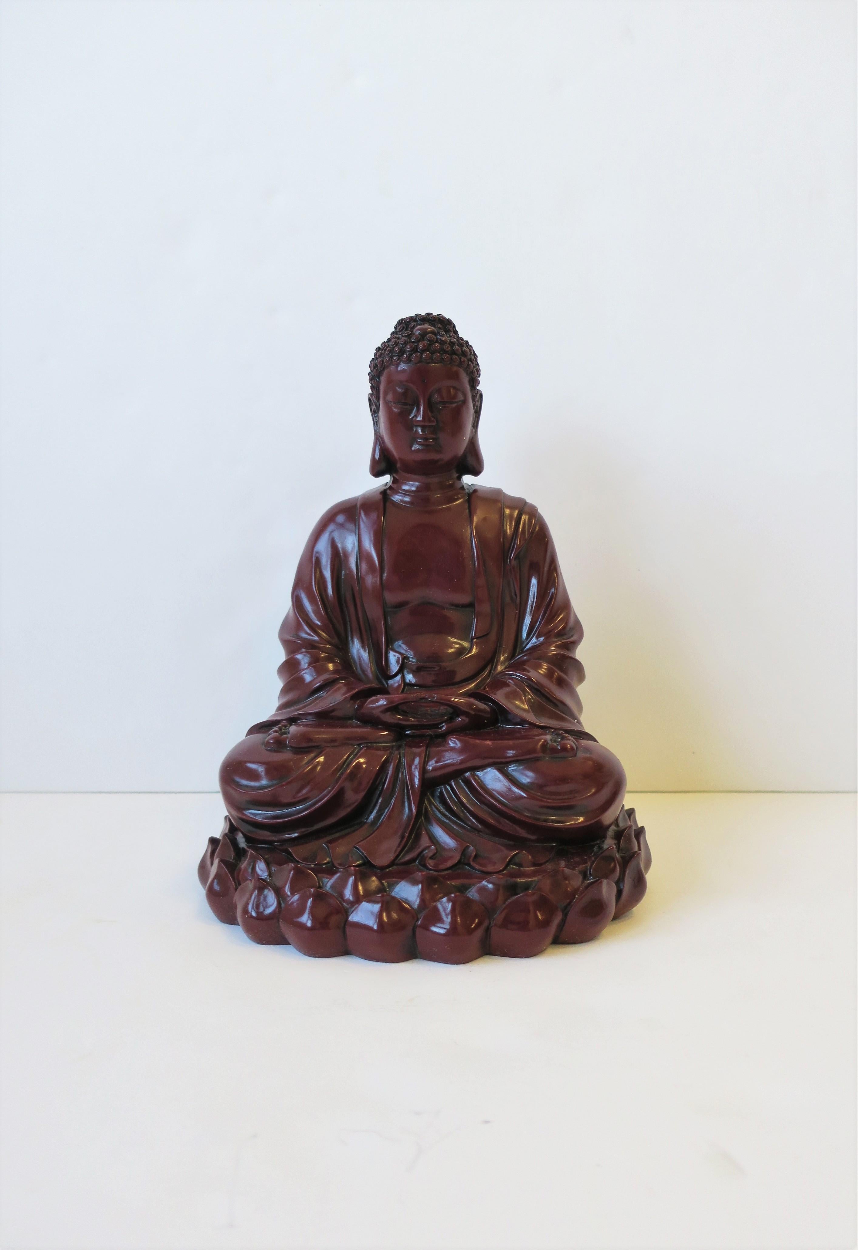 Beachtliches Dekorationsobjekt aus dunkelrotem, bordeauxfarbenem Harz, sitzende Buddha-Statue, ca. Ende des 20. Jahrhunderts. Dieser Buddha ist relativ groß und trägt ein Gewand in sitzender, meditierender Position mit einem Lotusblattmuster um die