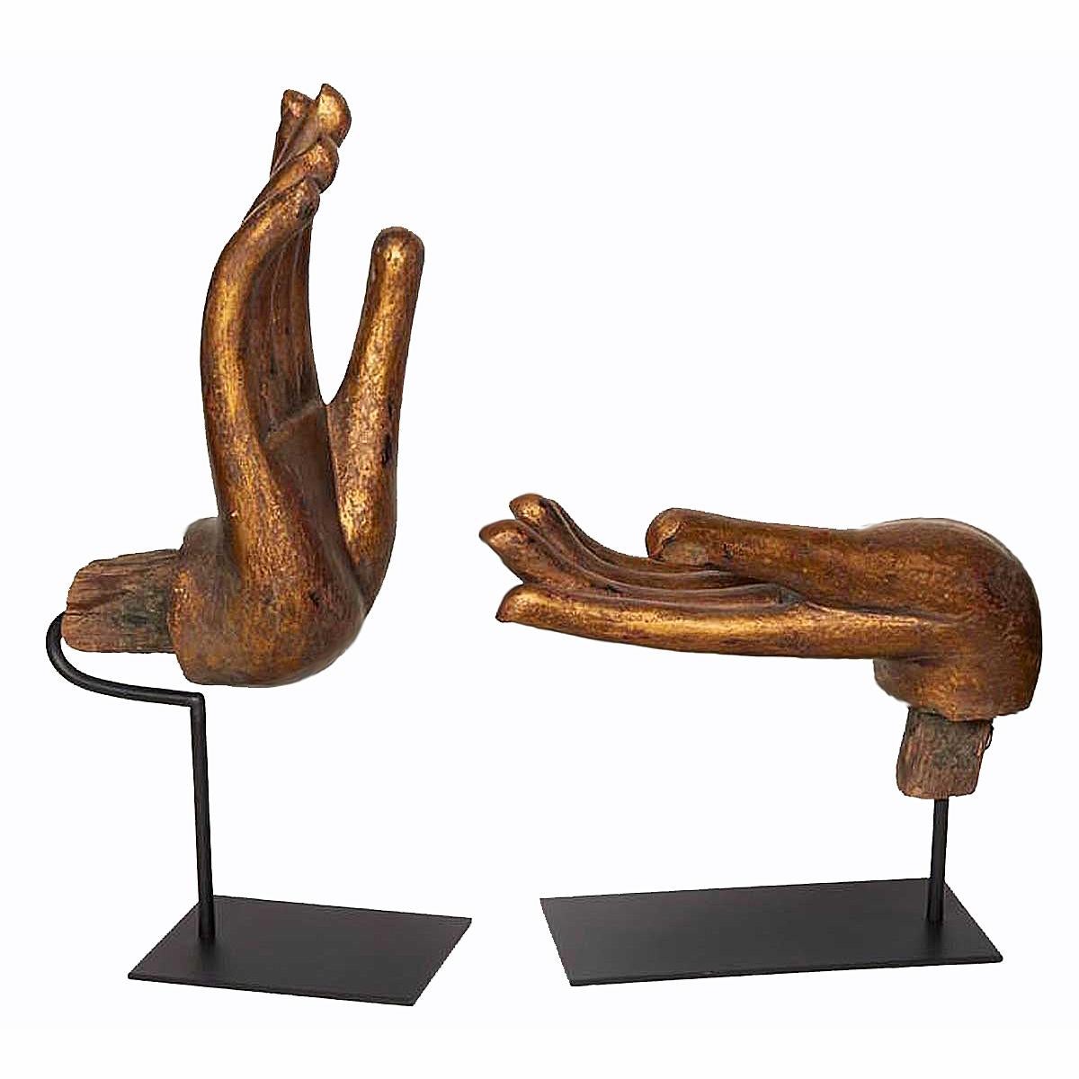 Two wooden Buddha hands, in gilt finish, each in a traditional gesture or mudra. Fingernails inlaid in mother of pearl. From Thailand, circa 1970. Mounted on black metal stands. Priced and sold separately. Dimensions of vertical hand shown