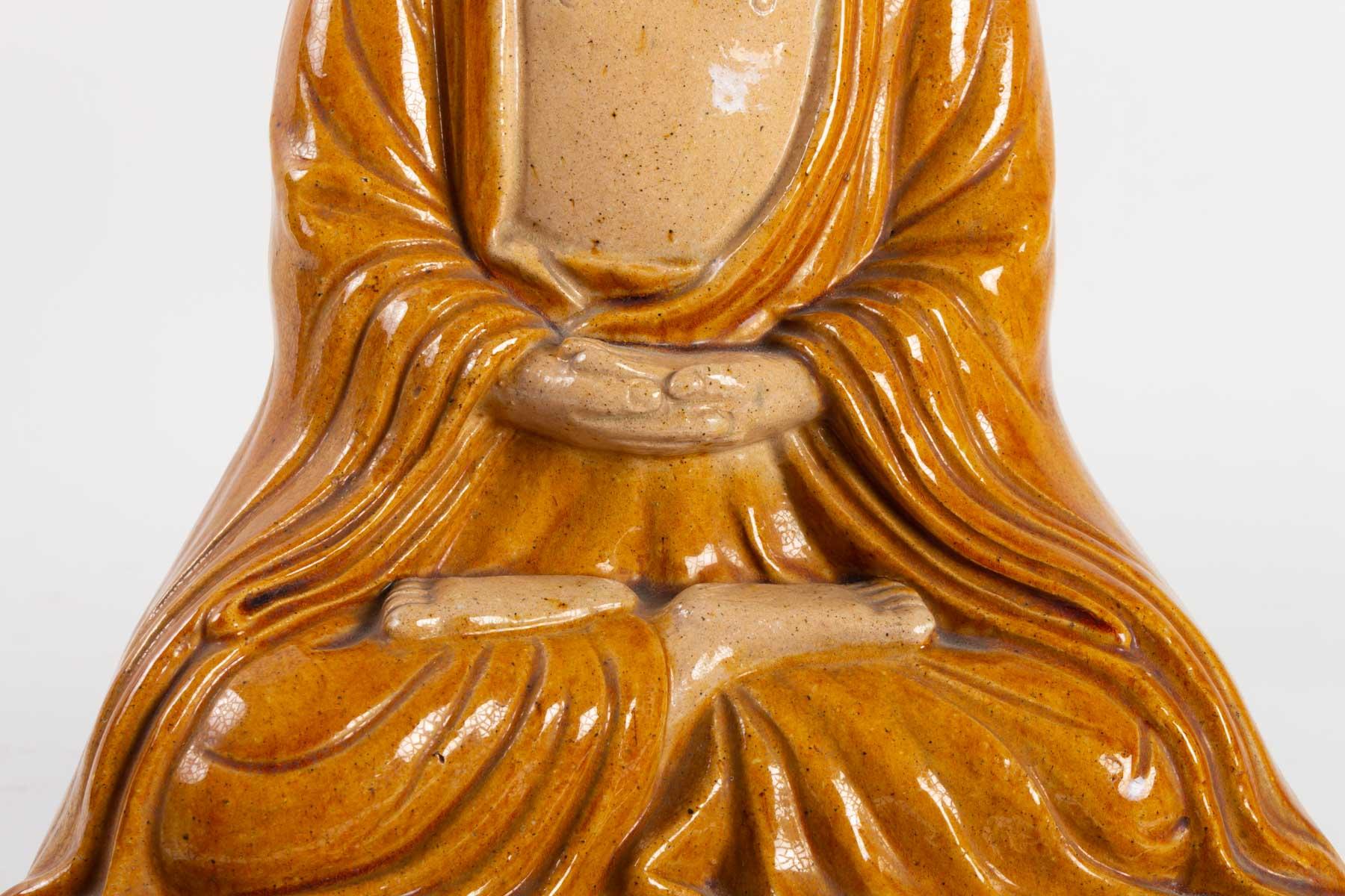 Buddha sitting on a lotus flower in enameled terracotta, yellow and green ochre, circa 1930.
Measures: H 47 cm, L 28 cm, W 20 cm.