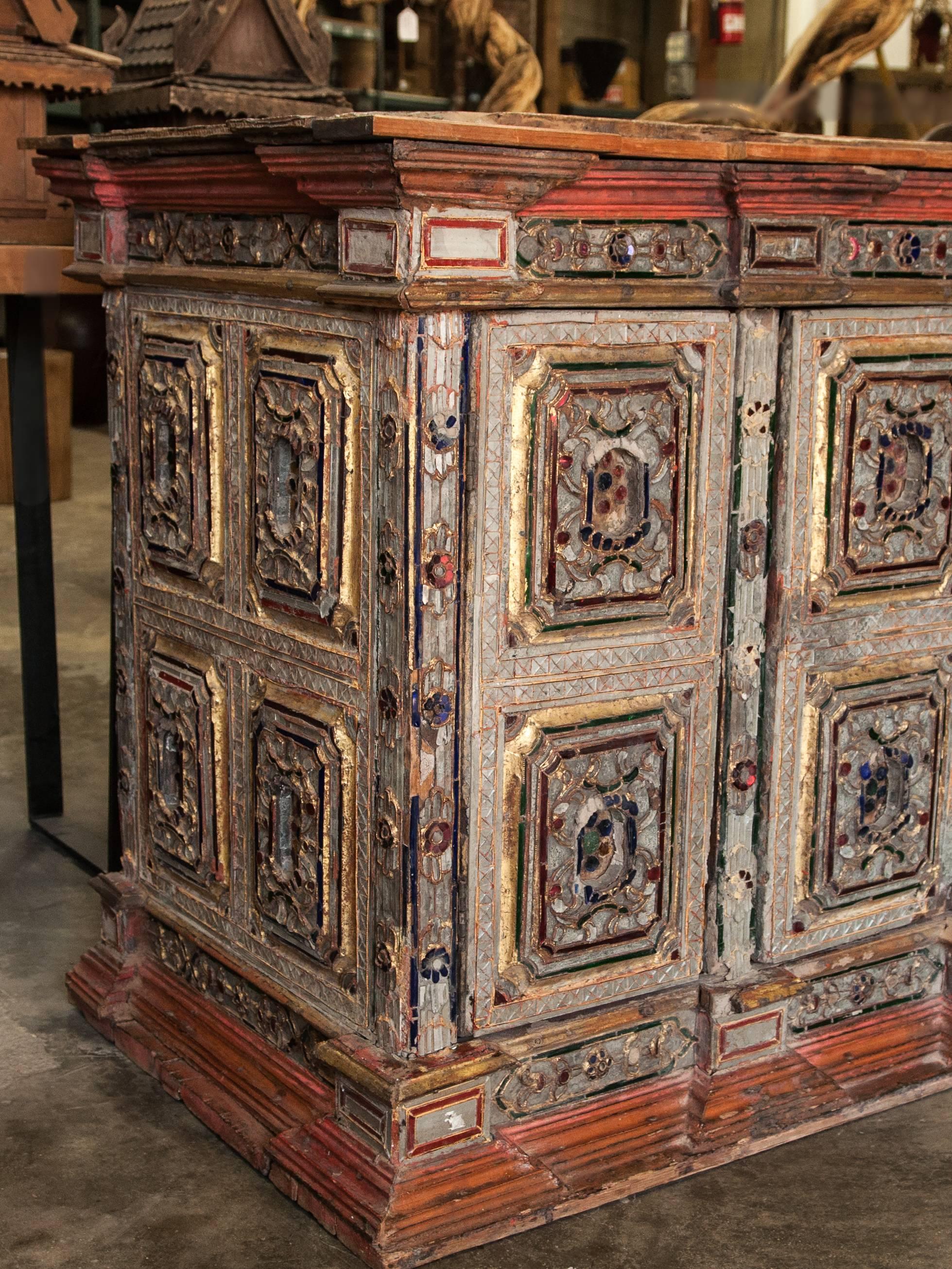 Buddhist teak scripture cabinet from Burma with inlay glass, early 20th century.
This scripture cabinet would have also served as a base for a religious statue or object, and to store religious texts and objects.
Dimensions: 37 inches wide by 27